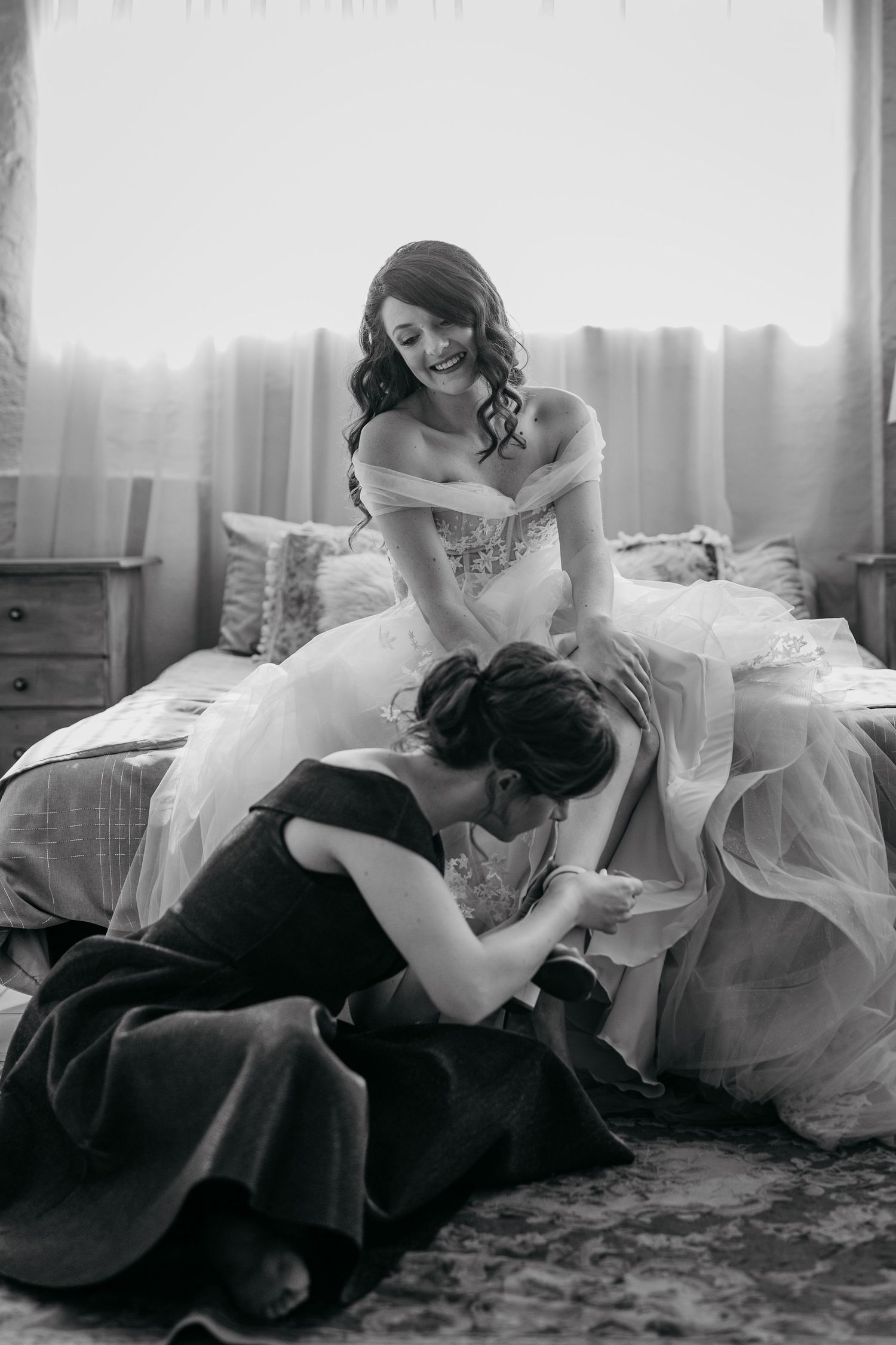 An emotional black and white moment between women during wedding preparations.