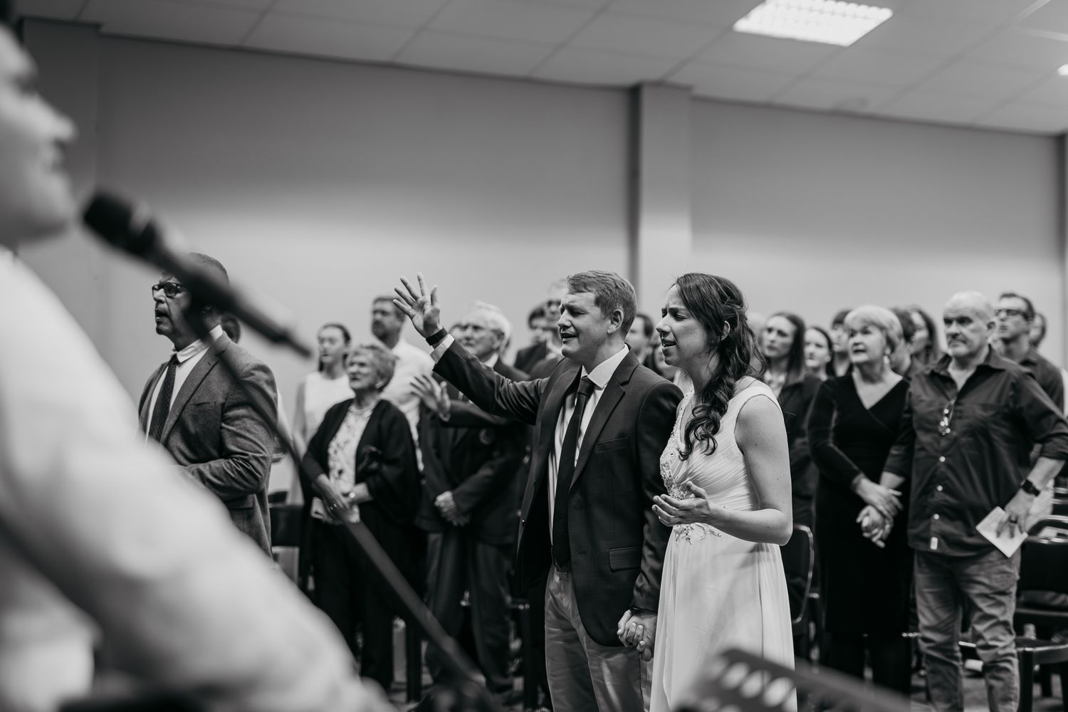 Wedding guests stand and applaud during an emotional ceremony moment.