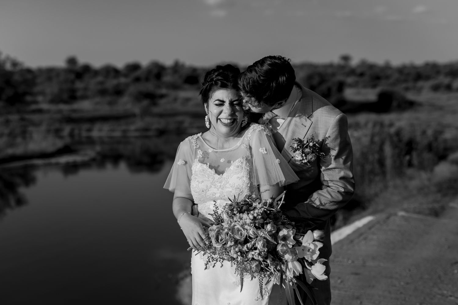 Black and white wedding portrait with couple by lakeside.