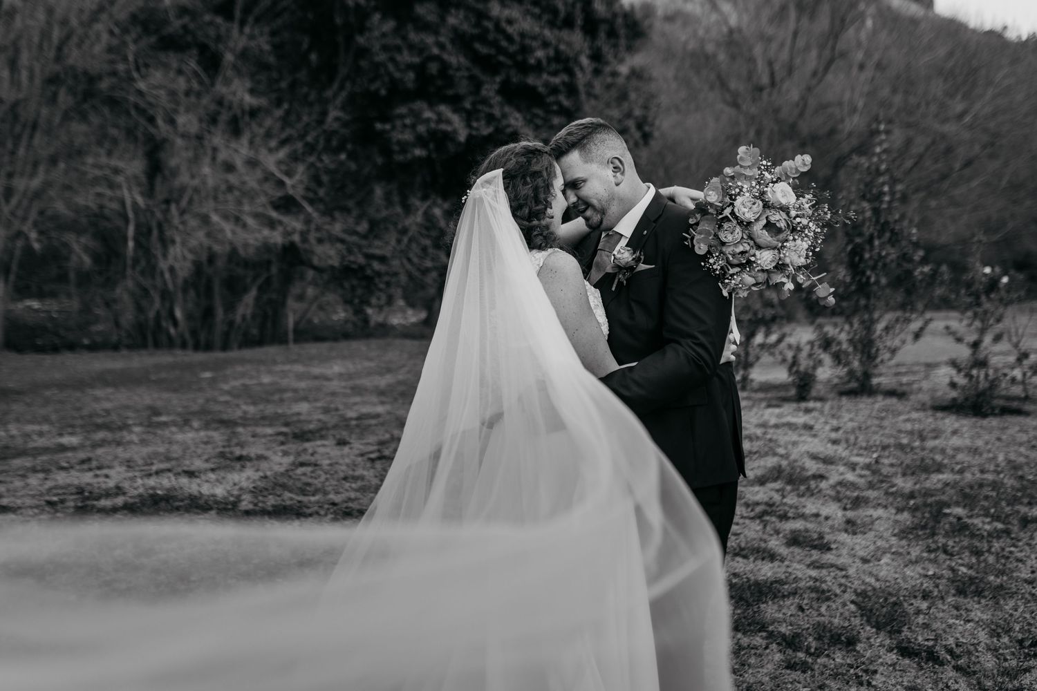 A series of black and white wedding photographs showing romantic moments between newlyweds in an outdoor garden setting.