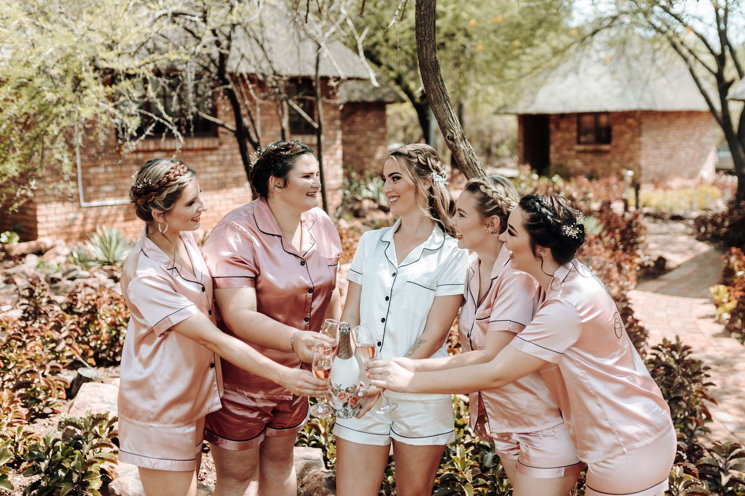 Group in coordinated sleepwear toasting together during an outdoor celebration.