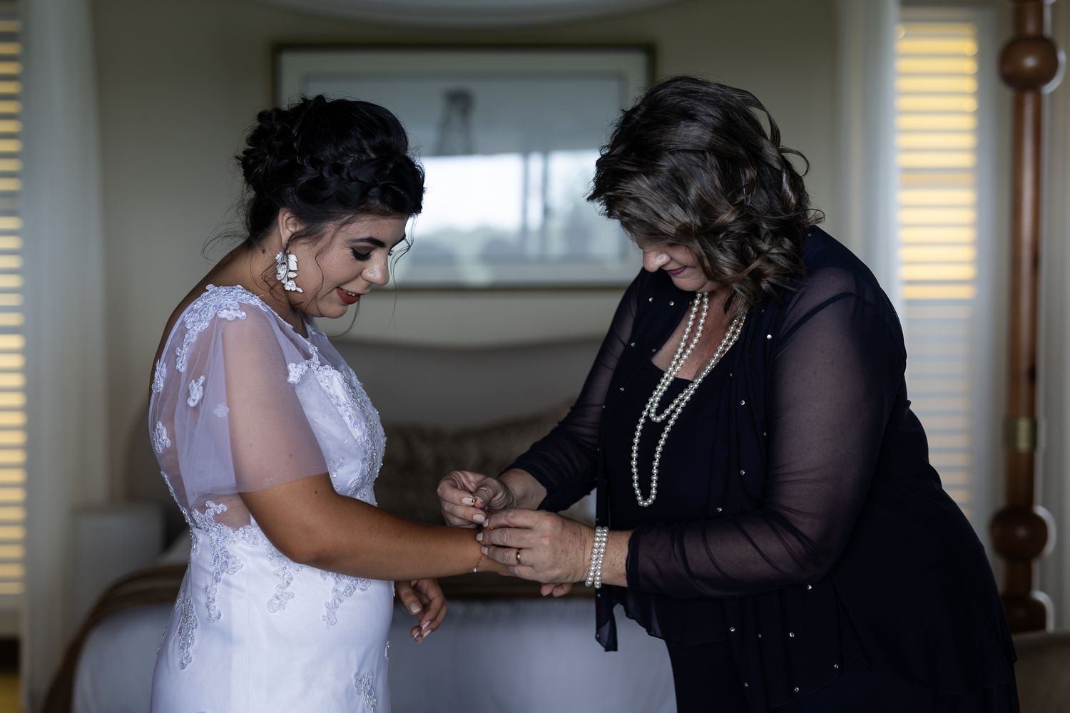 Two people share an emotional moment while holding hands during wedding preparations.