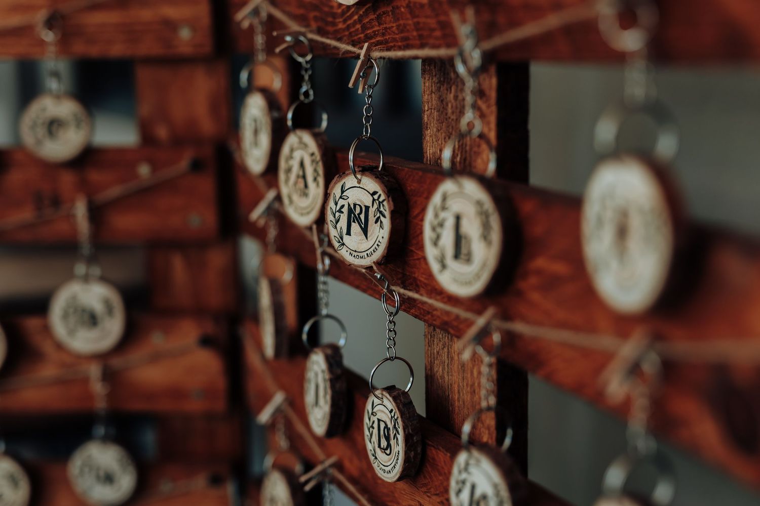 Decorative hanging circular name tags against a rustic brick wall background.