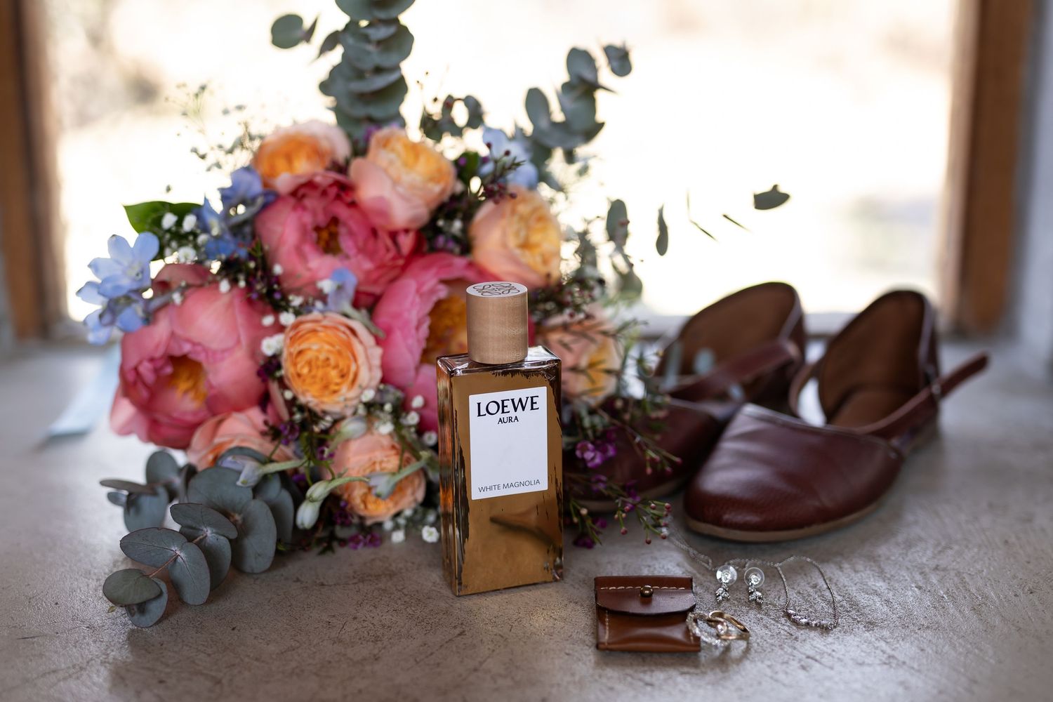 Pink and peach roses styled with delicate eucalyptus leaves create an elegant floral arrangement display.