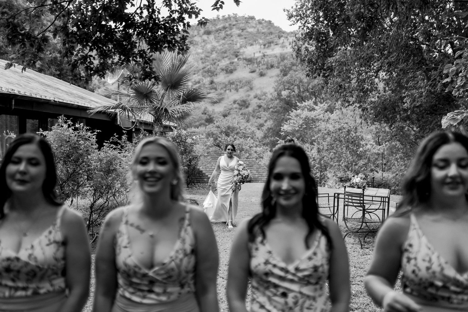 Black and white photo of bridesmaids laughing together outdoors.