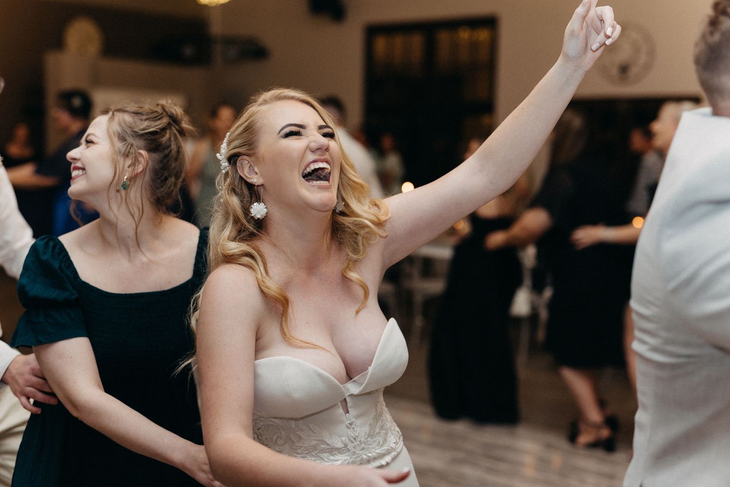 Wedding celebration captured mid-dance with guests enjoying lively moments on the dance floor.