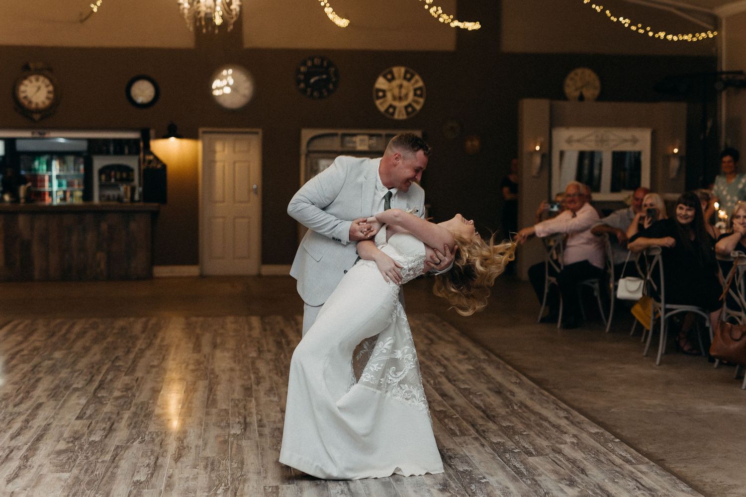 Dynamic dance performance during wedding reception with beautiful string light decorations overhead.