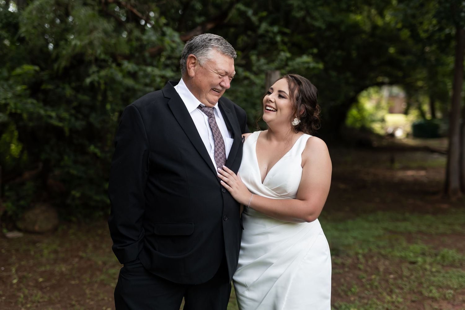 A sweet candid moment shared between two people during an outdoor wedding photoshoot.
