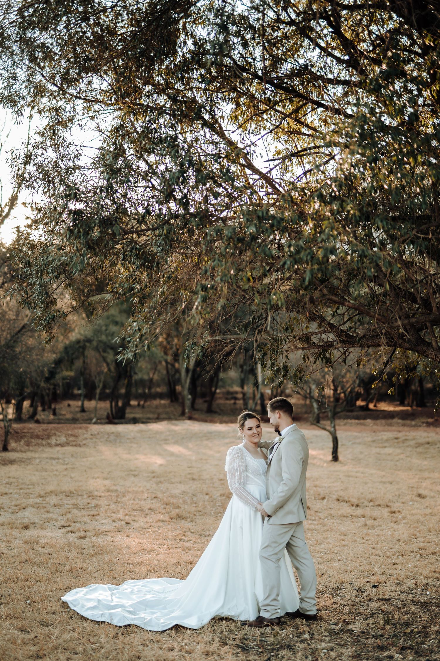 Intimate wedding portrait showing tender moment between couple in natural outdoor setting.