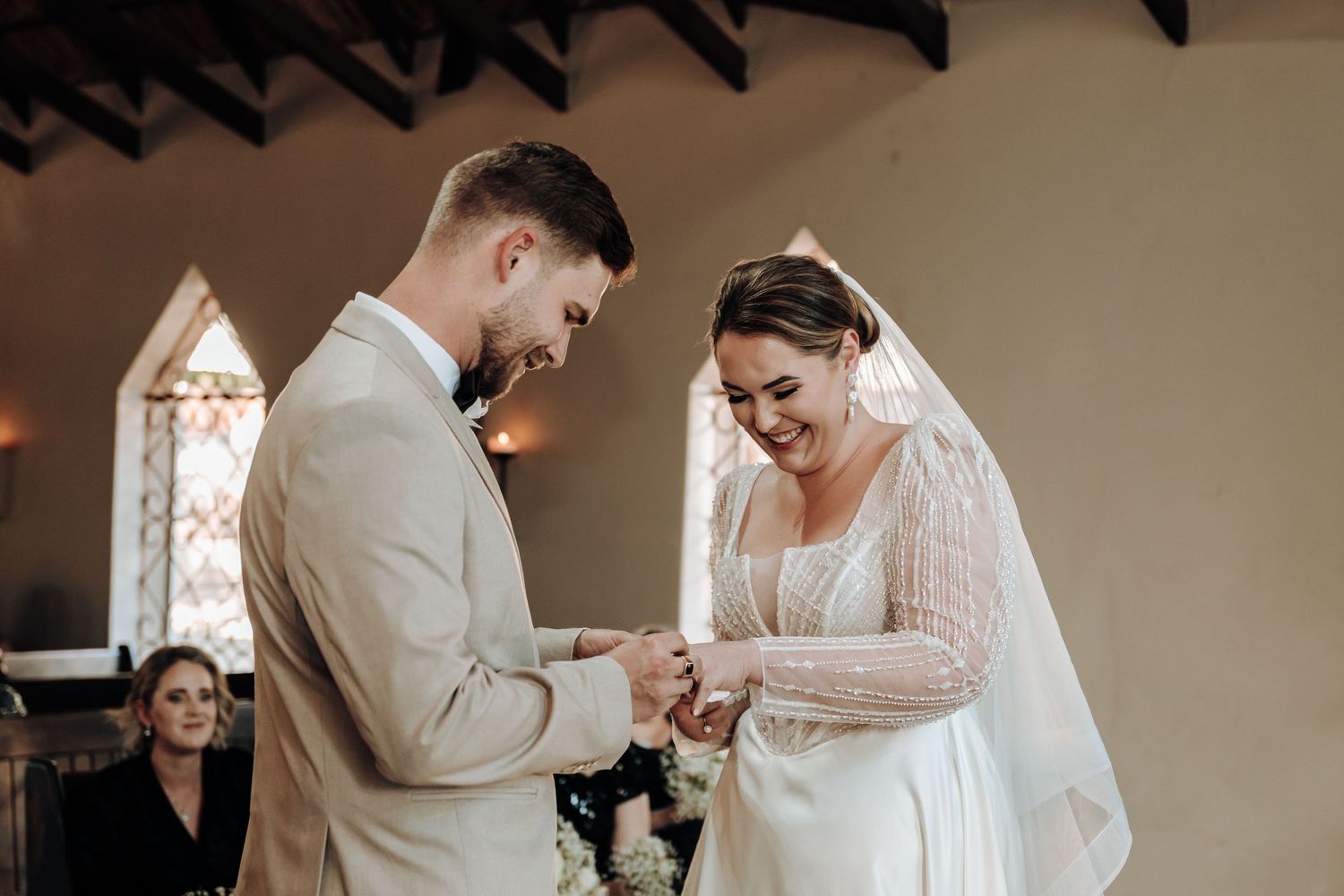 A couple exchanges rings during an intimate wedding ceremony in a historic chapel.