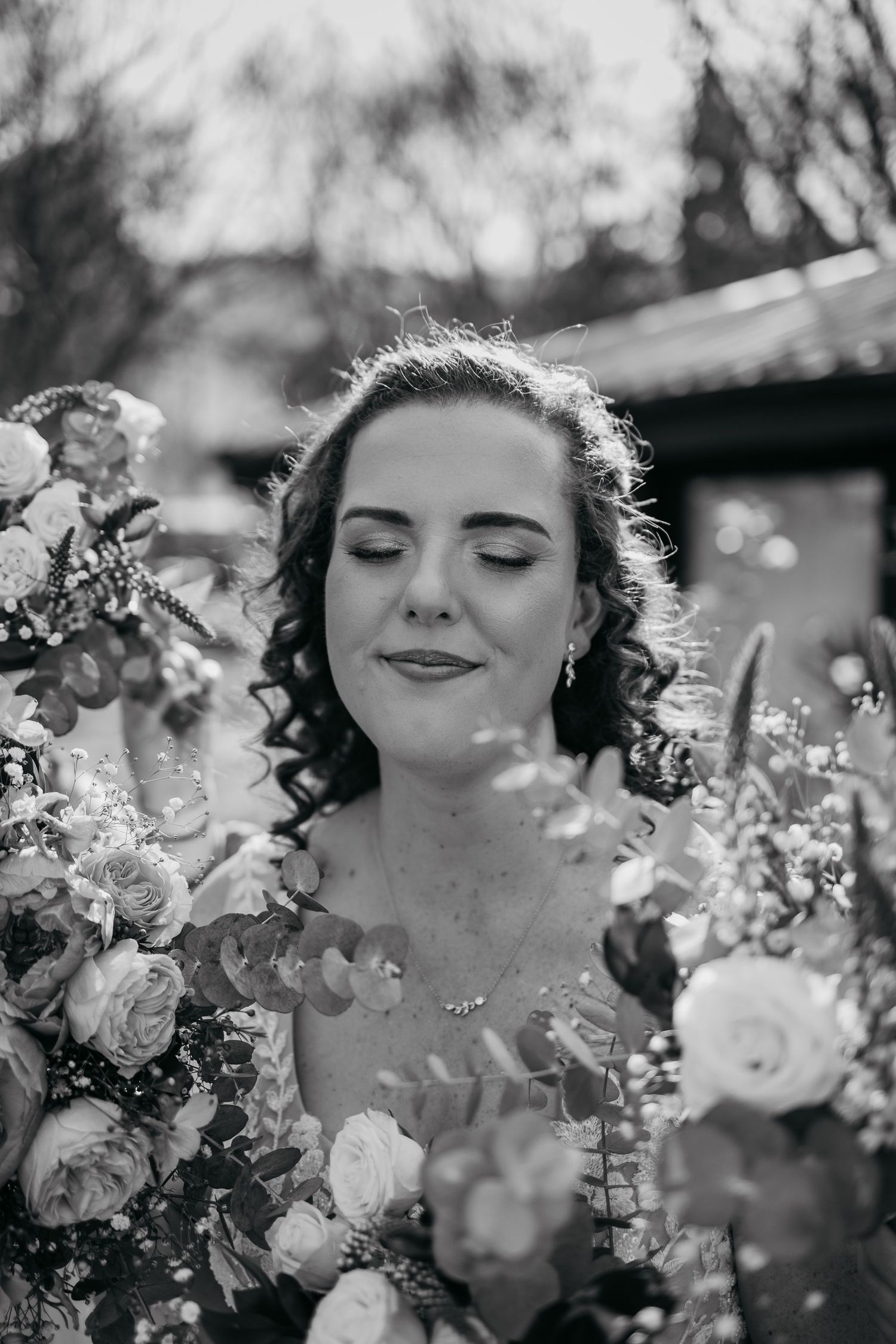 Artistic close-up portraits showcase subject with spring blossoms creating ethereal black and white series.