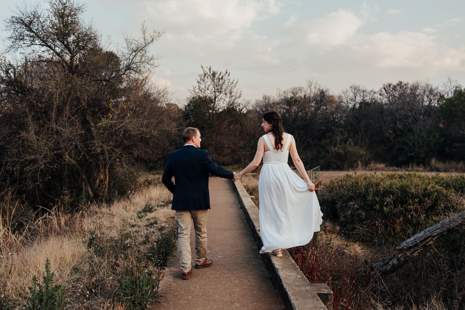 Natural outdoor wedding venue path lined with autumn trees under cloudy skies.
