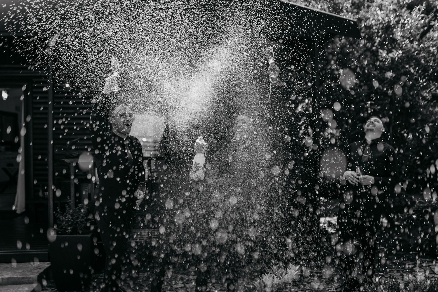 Black and white photo of champagne spray creating a dramatic misty effect.