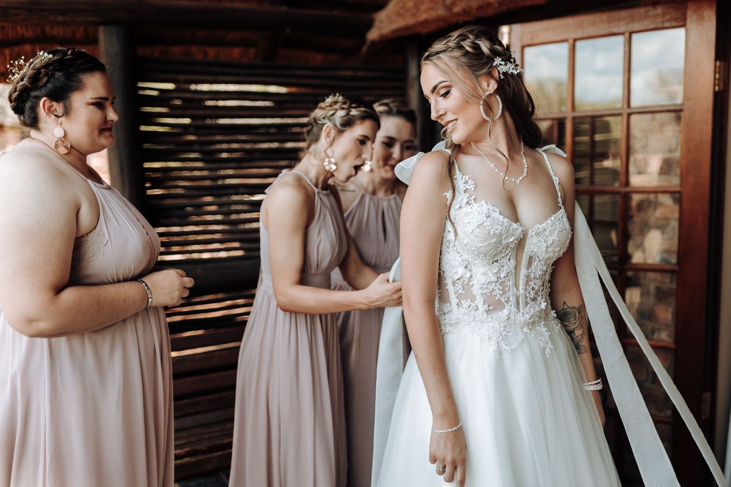A tender moment captured between wedding party members in a rustic venue.