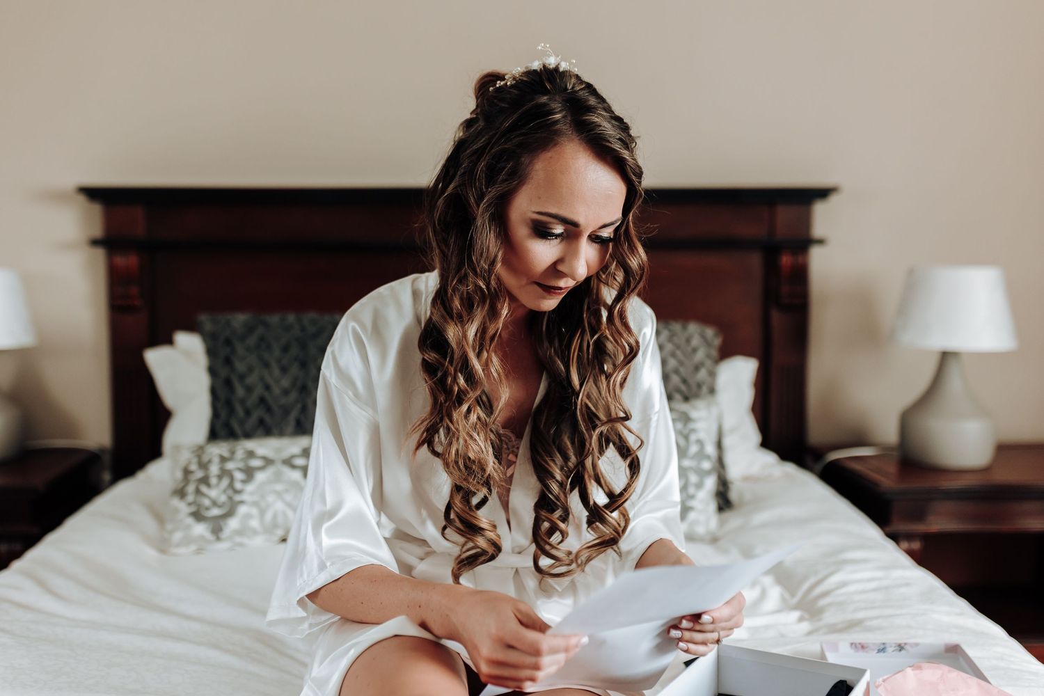 Wedding morning preparation scene in elegant bedroom setting.