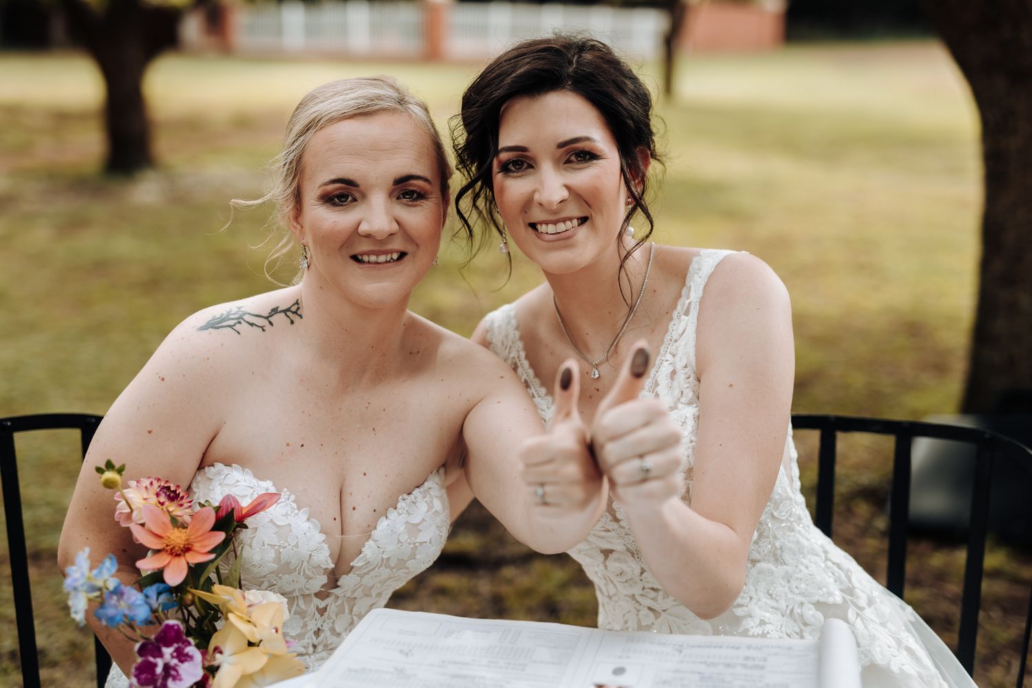Happy wedding couple celebrating outdoors with colorful bouquet.