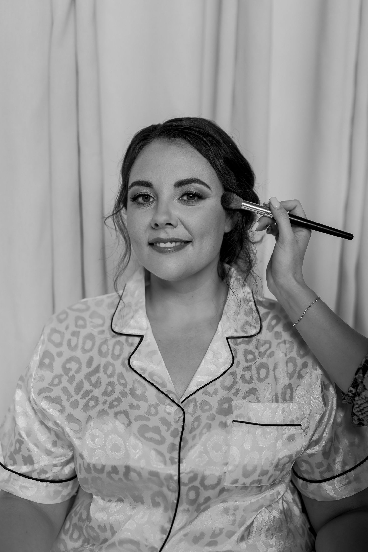 Black and white portrait during makeup application in leopard print robe.