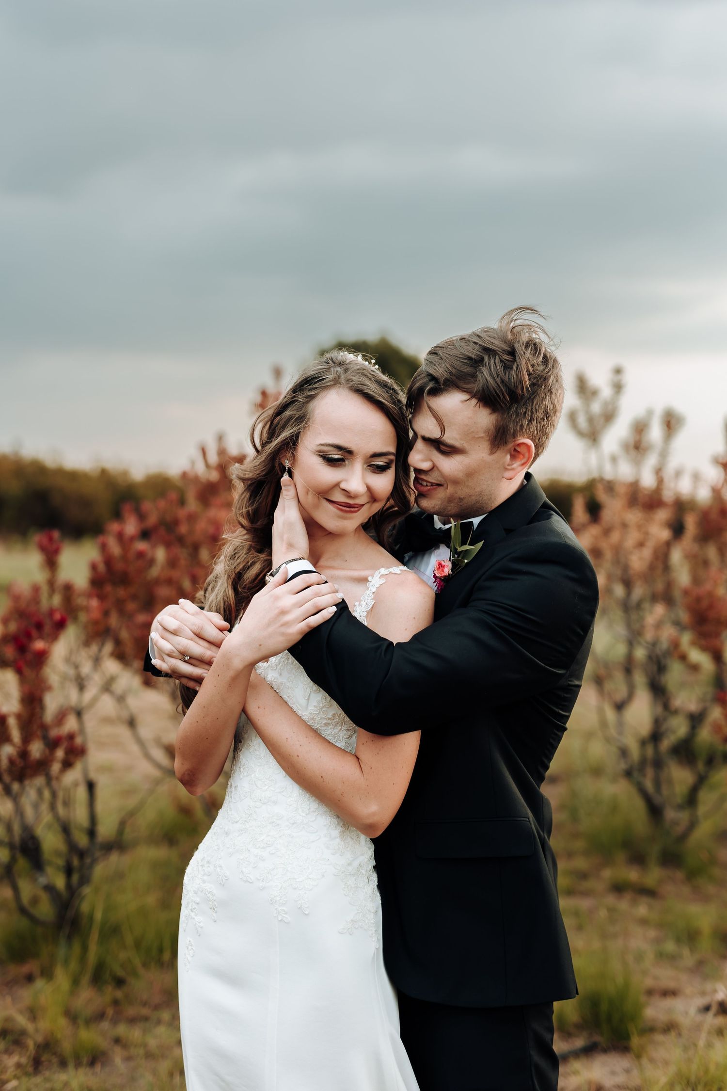 Intimate moment between couple during outdoor autumn wedding photoshoot.