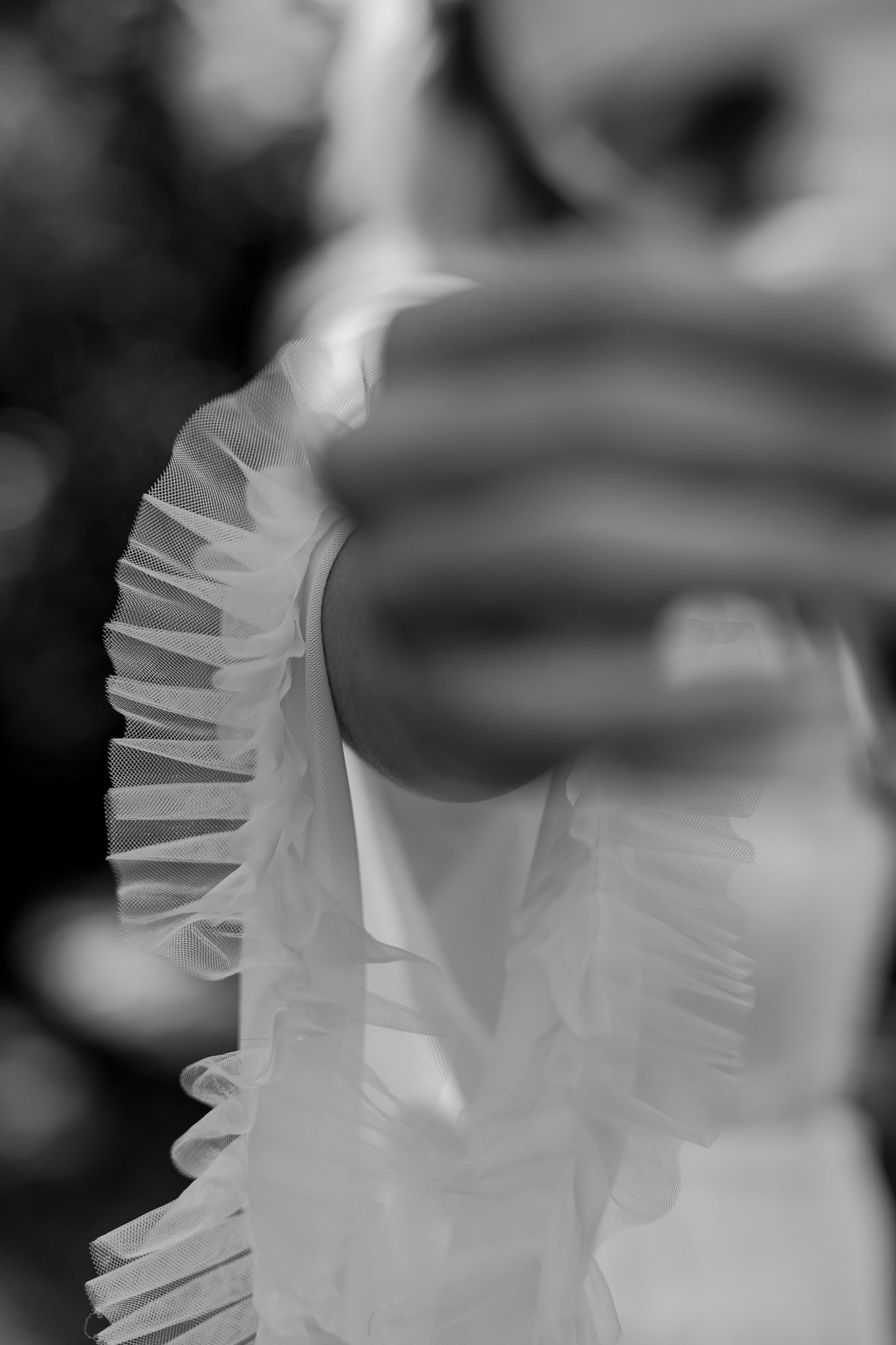 Abstract black and white close-up of ruffled white fabric with soft bokeh background.