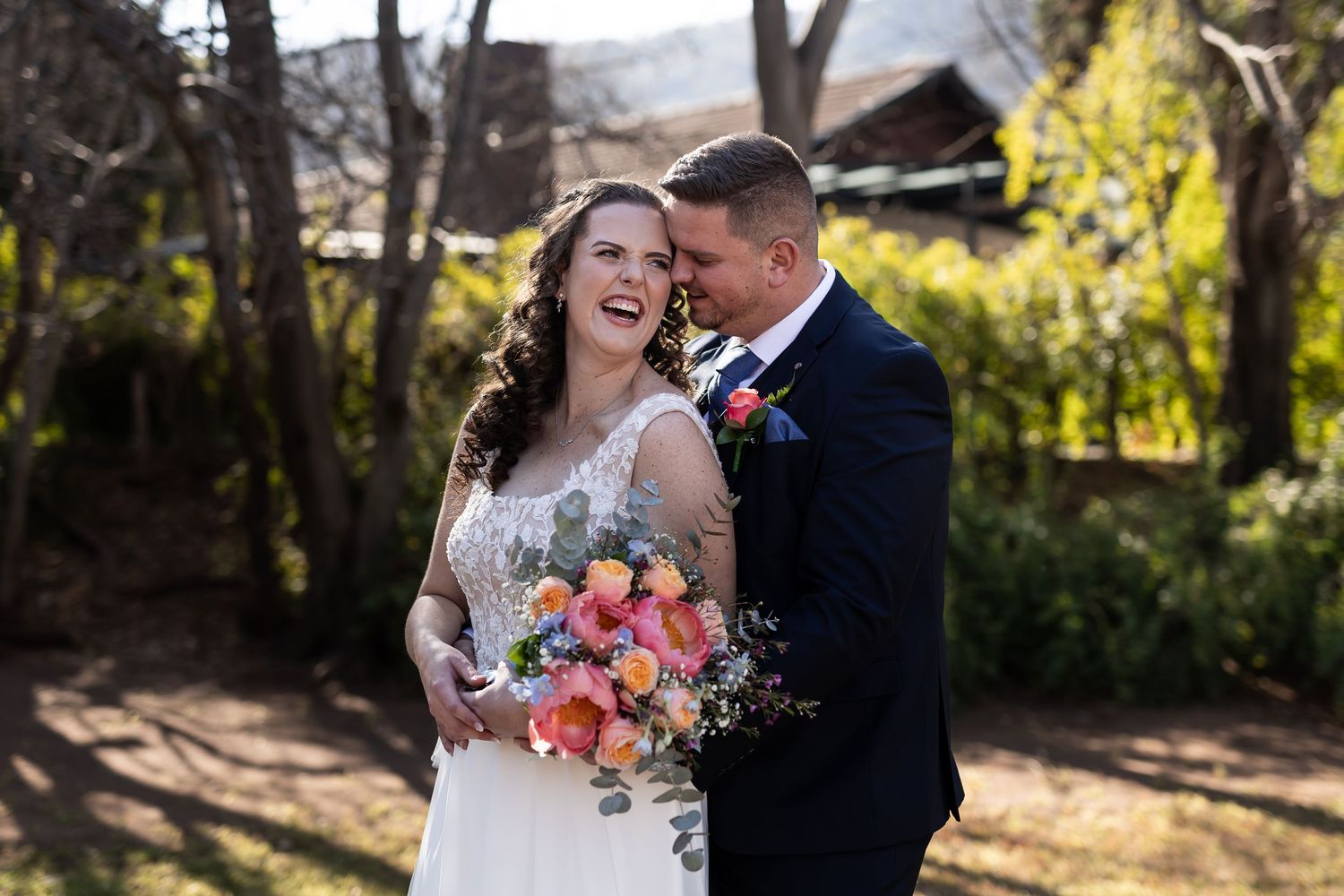 Newlywed couple shares intimate moments in picturesque outdoor garden settings with vibrant floral bouquets.