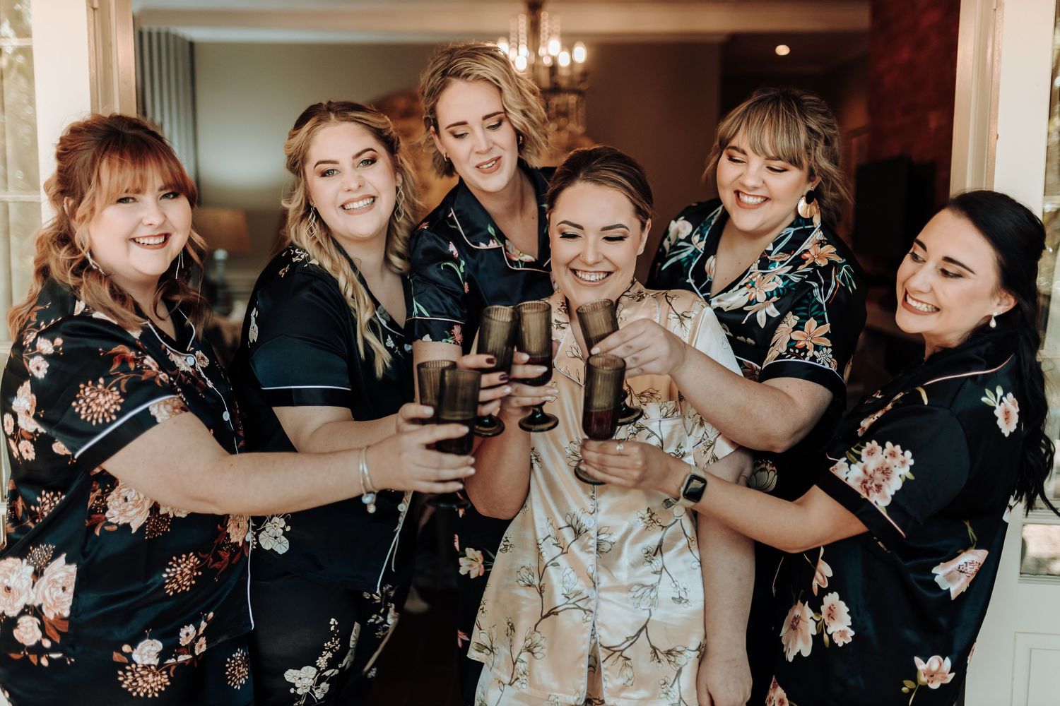 A festive group in coordinated floral robes toasting with drinks.