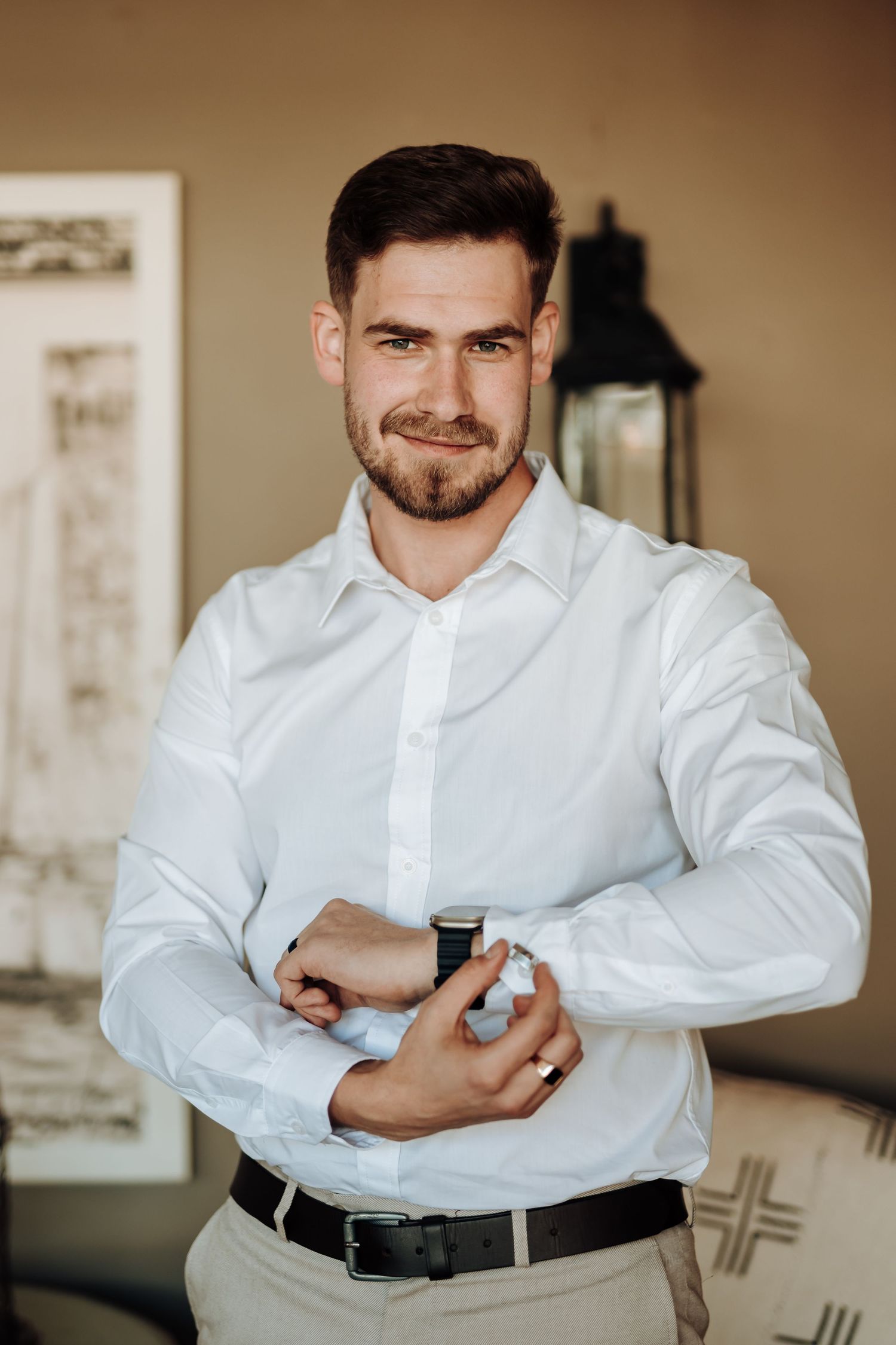 Formal attire with crisp white shirt and smartwatch in an elegant room with vintage decor.