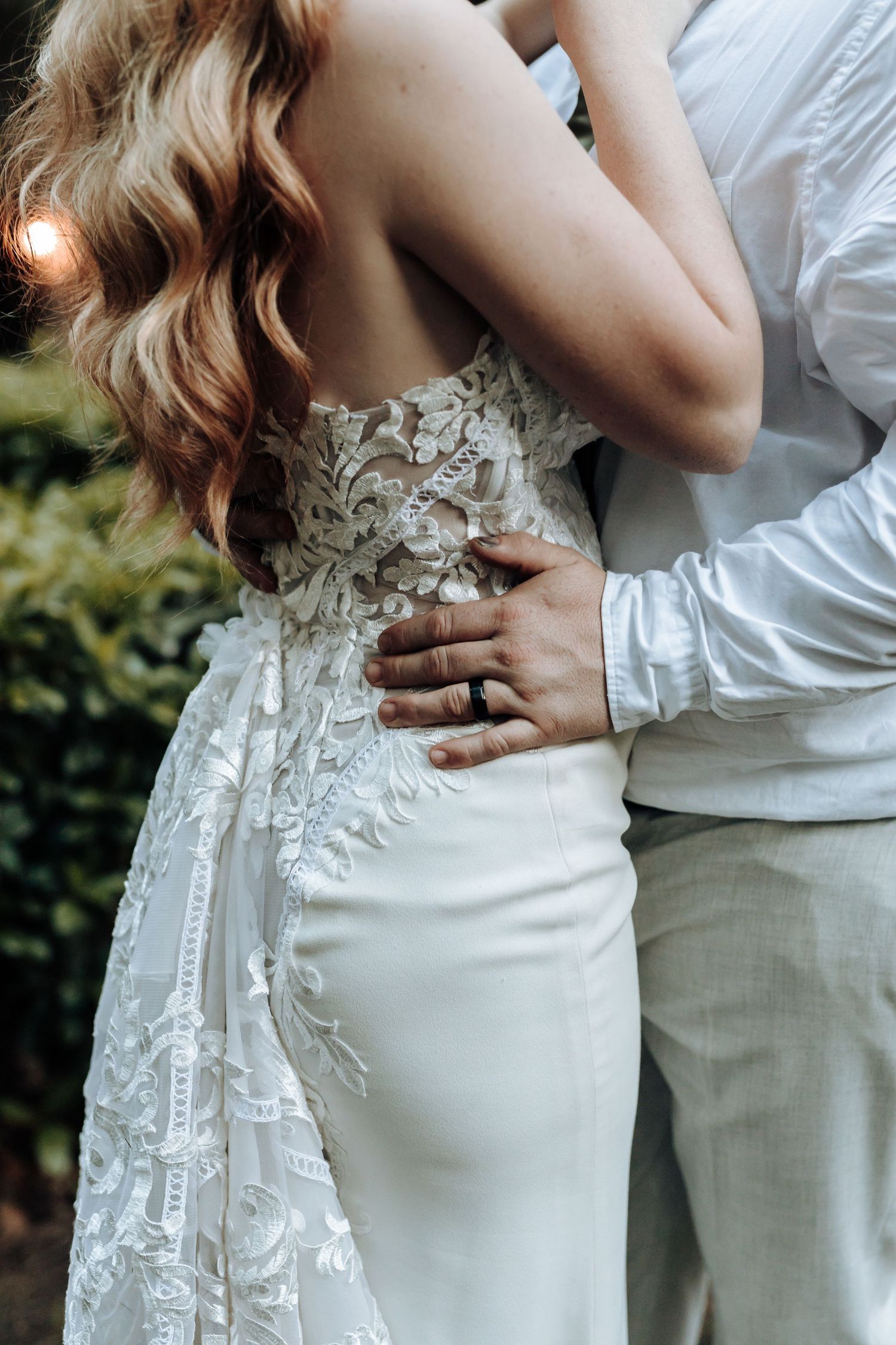 Close-up detail of an intricate lace wedding dress with floral appliques.