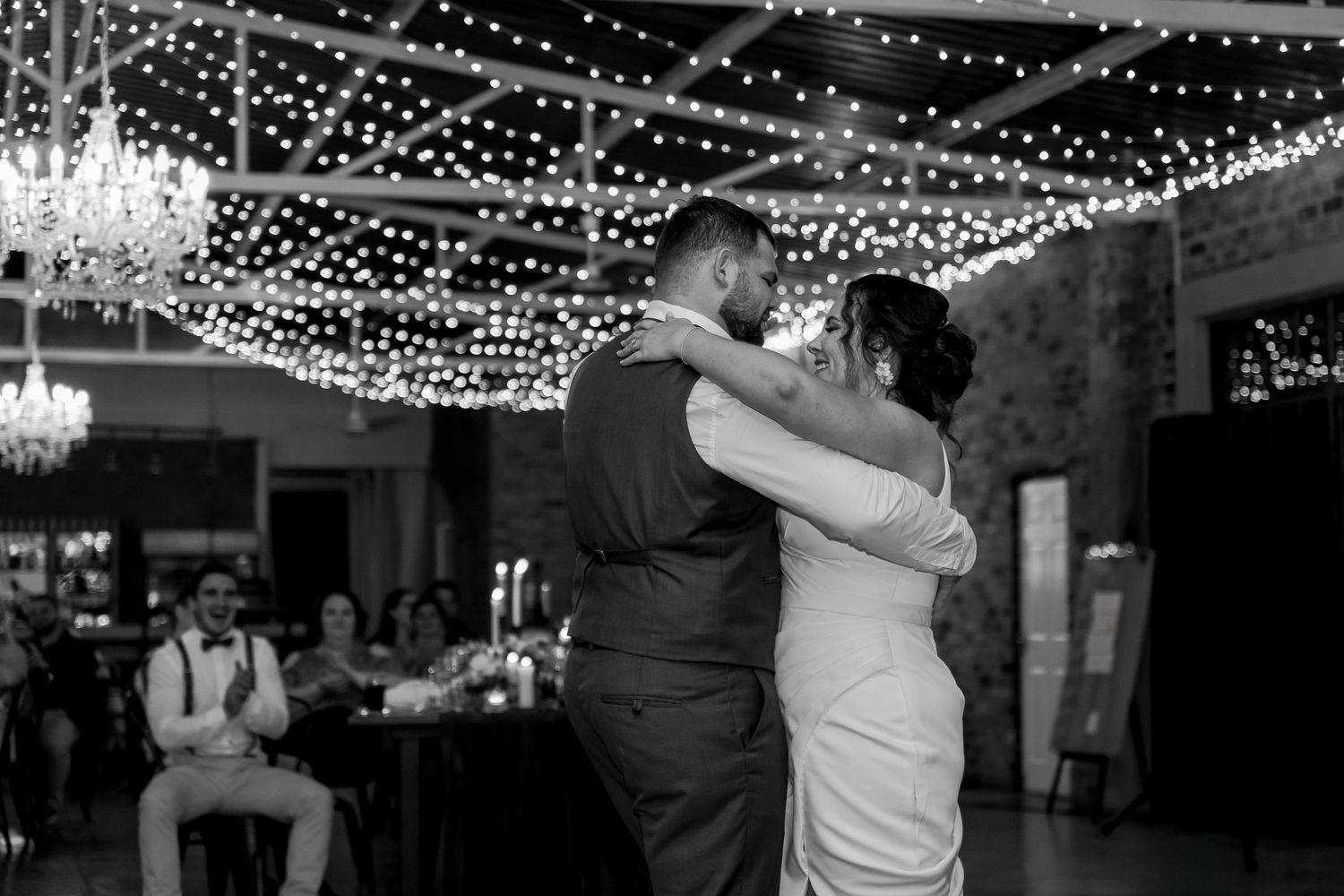 Black and white reception dance with string lights creating romantic ambiance.