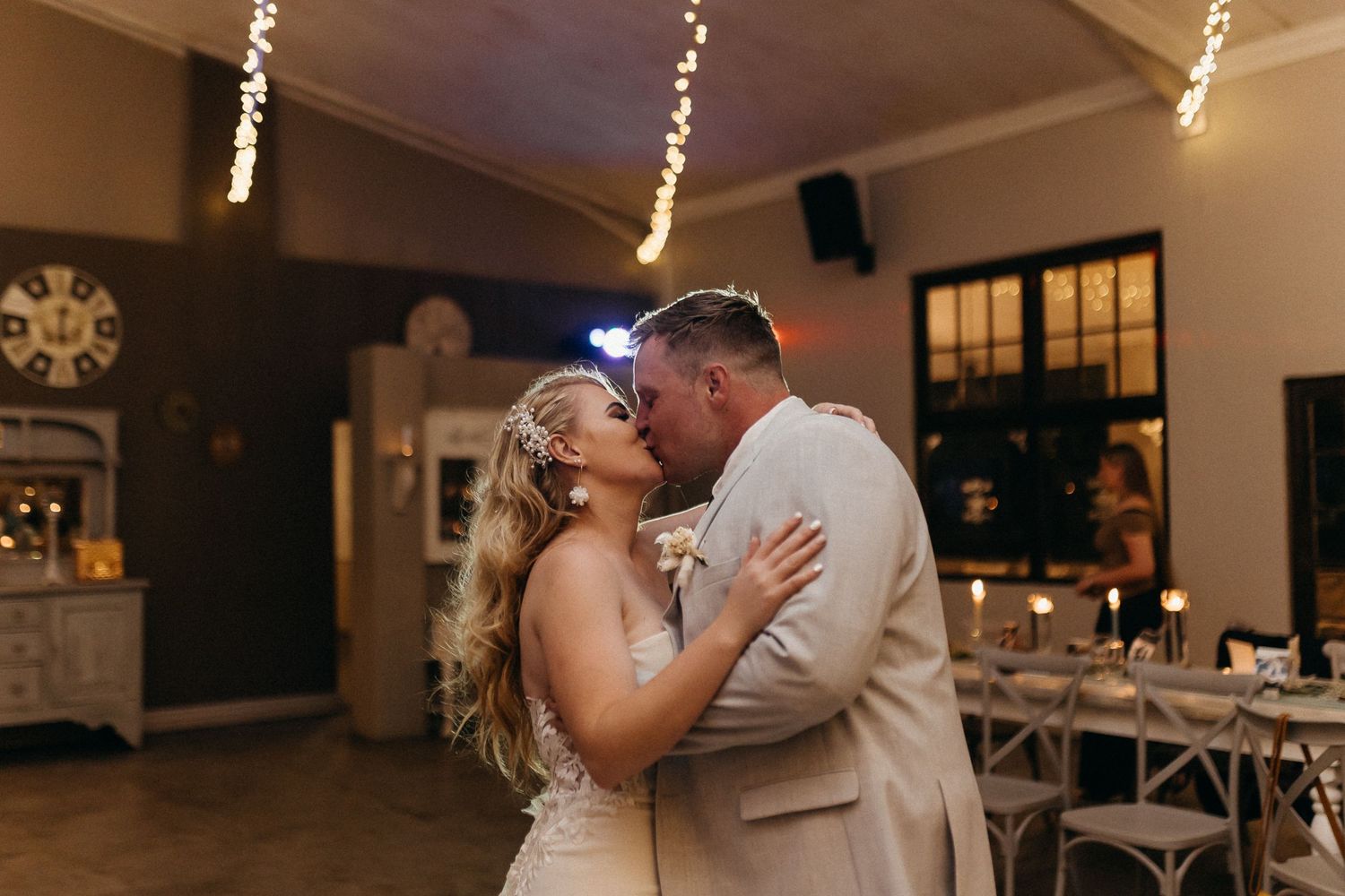Newlyweds sharing romantic dance moment in dimly lit reception venue.