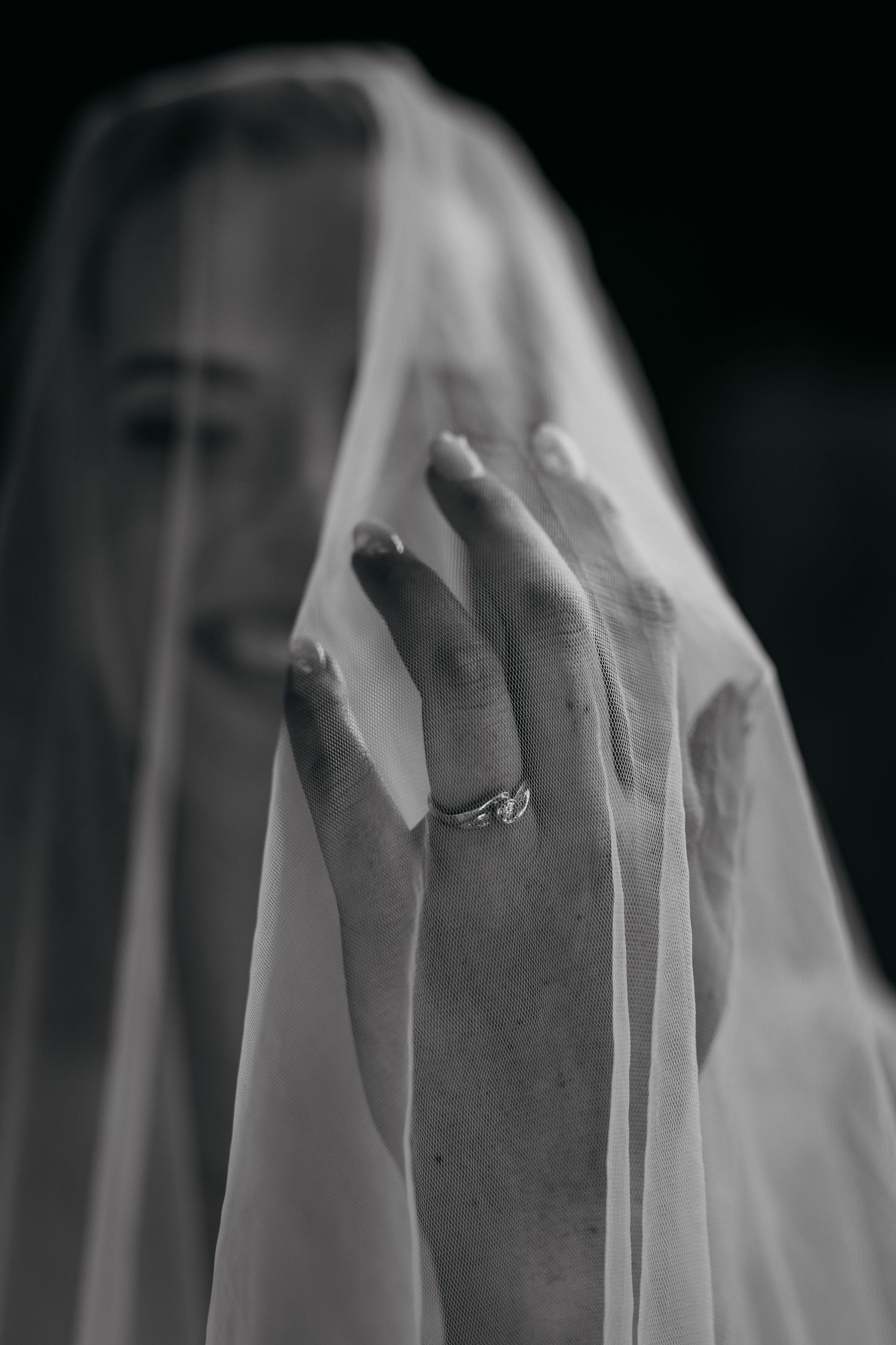 Five black and white photos of hands wearing engagement rings against a dark background show a progressive sequence.