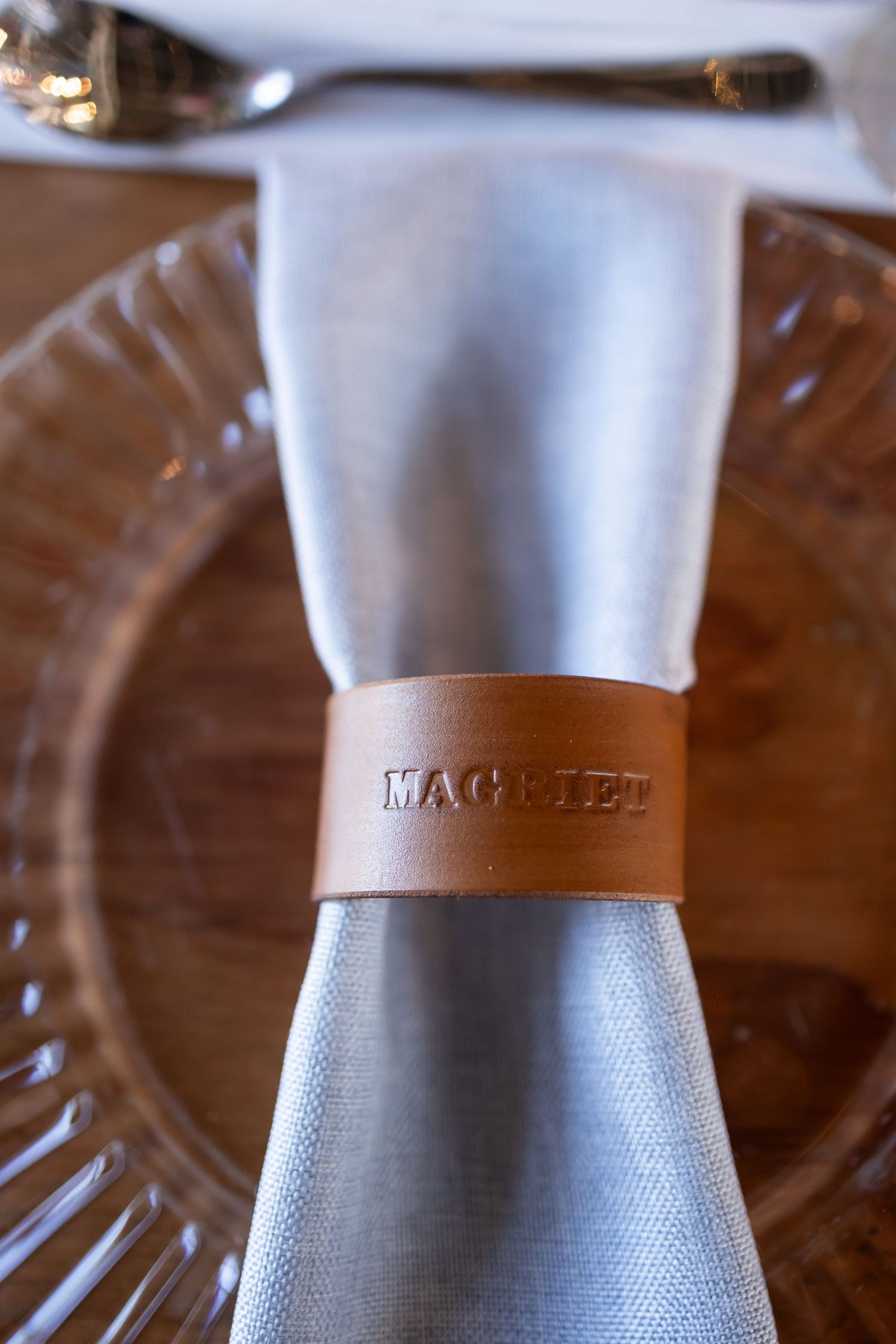 Close up macro photography details of steel coffee grinder textures with leather grip in warm lighting.