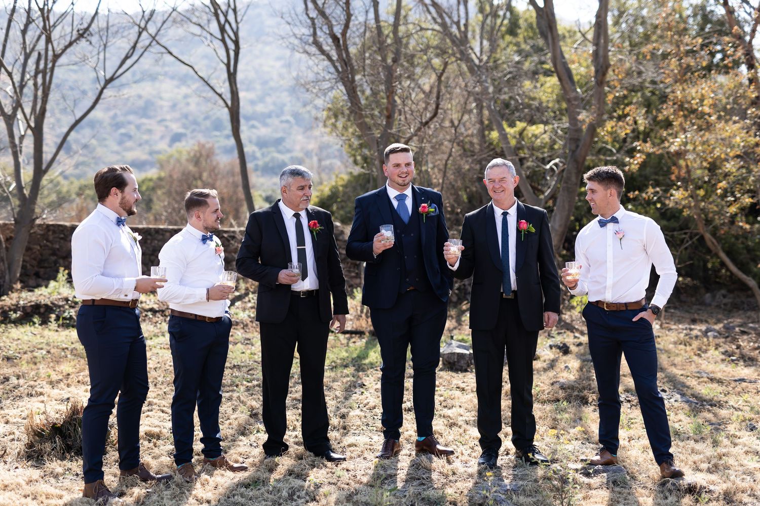 A black and white collage of groomsmen enjoying candid moments at an outdoor wedding celebration.