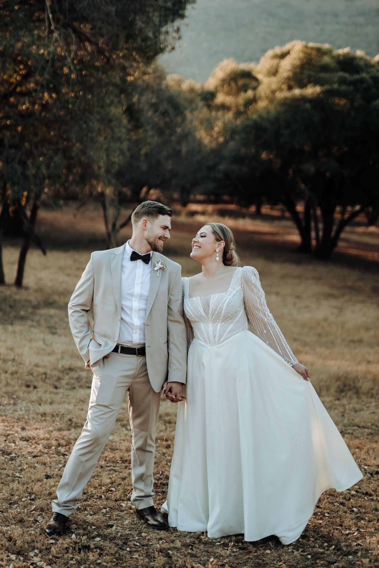 A couple in formal wedding attire share a joyful moment together on their special day.