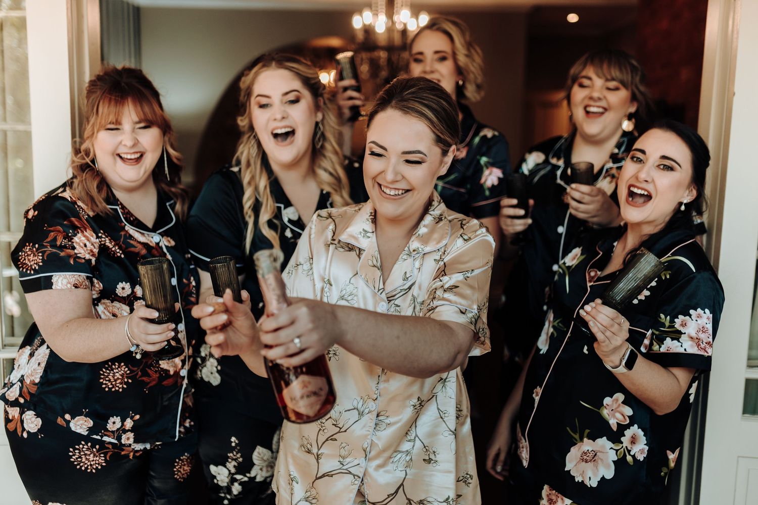 A joyful celebration with matching floral robes and beverages.