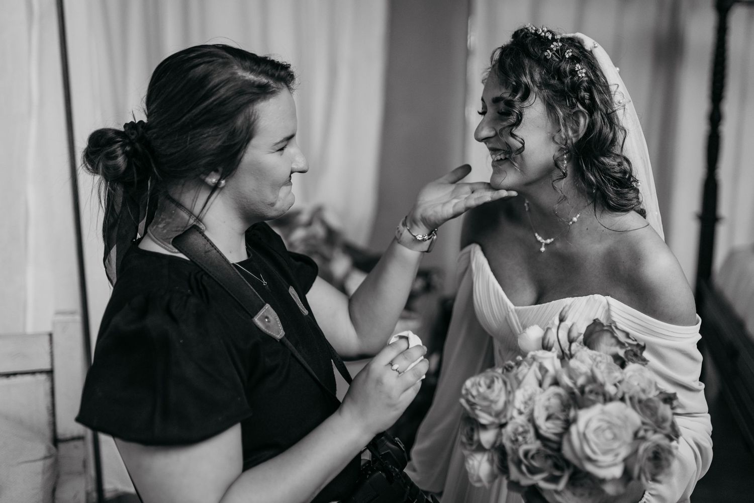 Black and white candid moment during wedding preparation with bouquet of roses.
