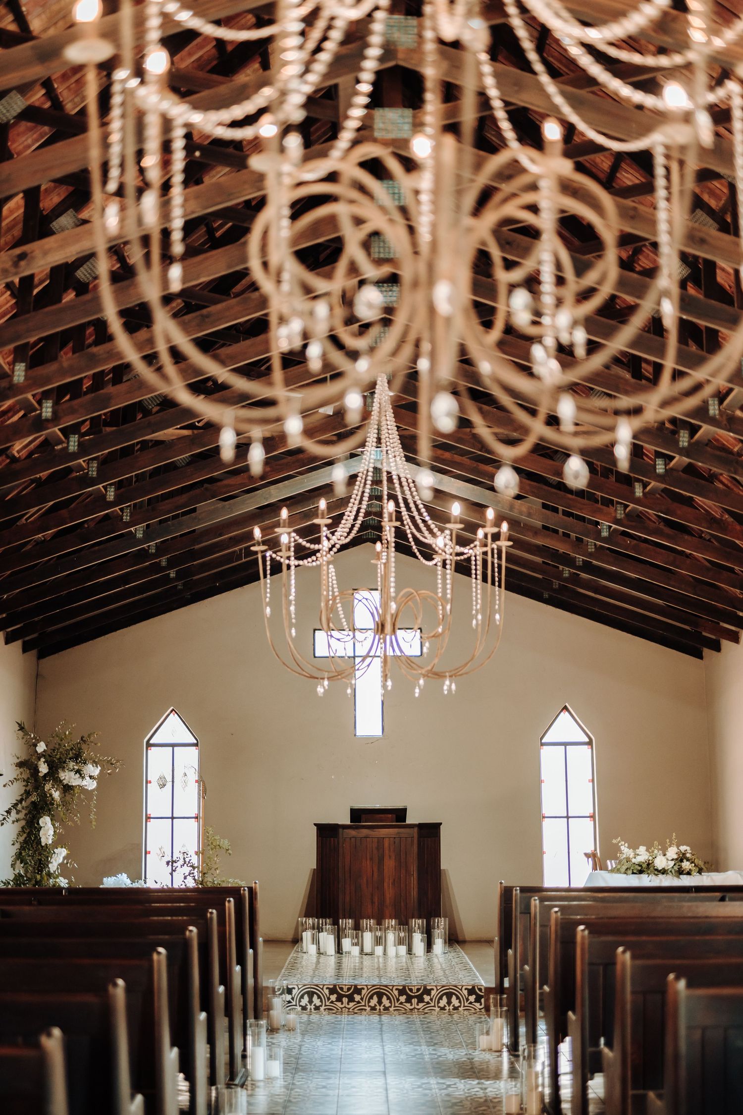 Chapel interior with elegant crystal chandelier and wooden beam ceiling.