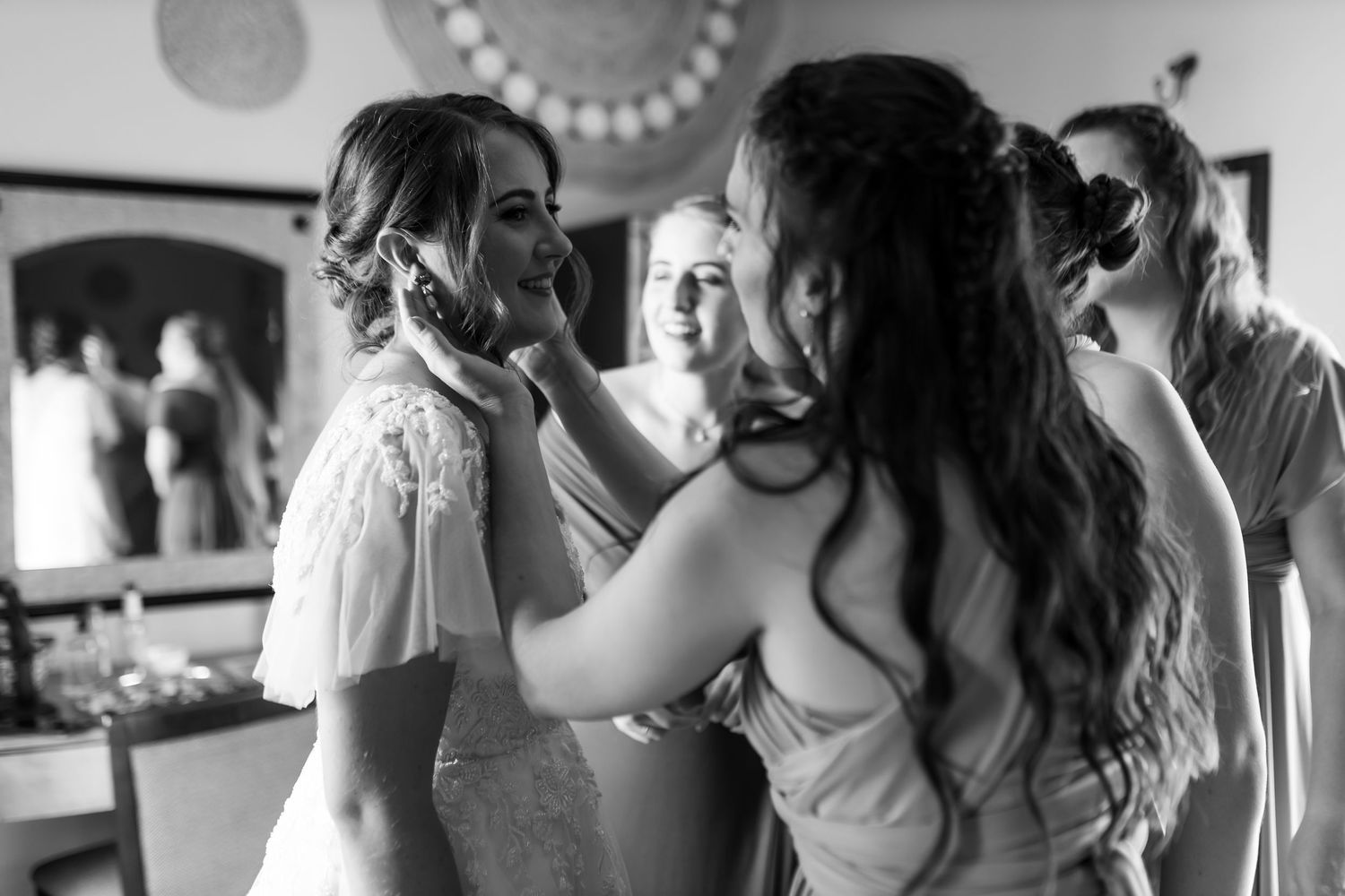 A black and white photo captures an intimate getting ready moment during wedding preparations.