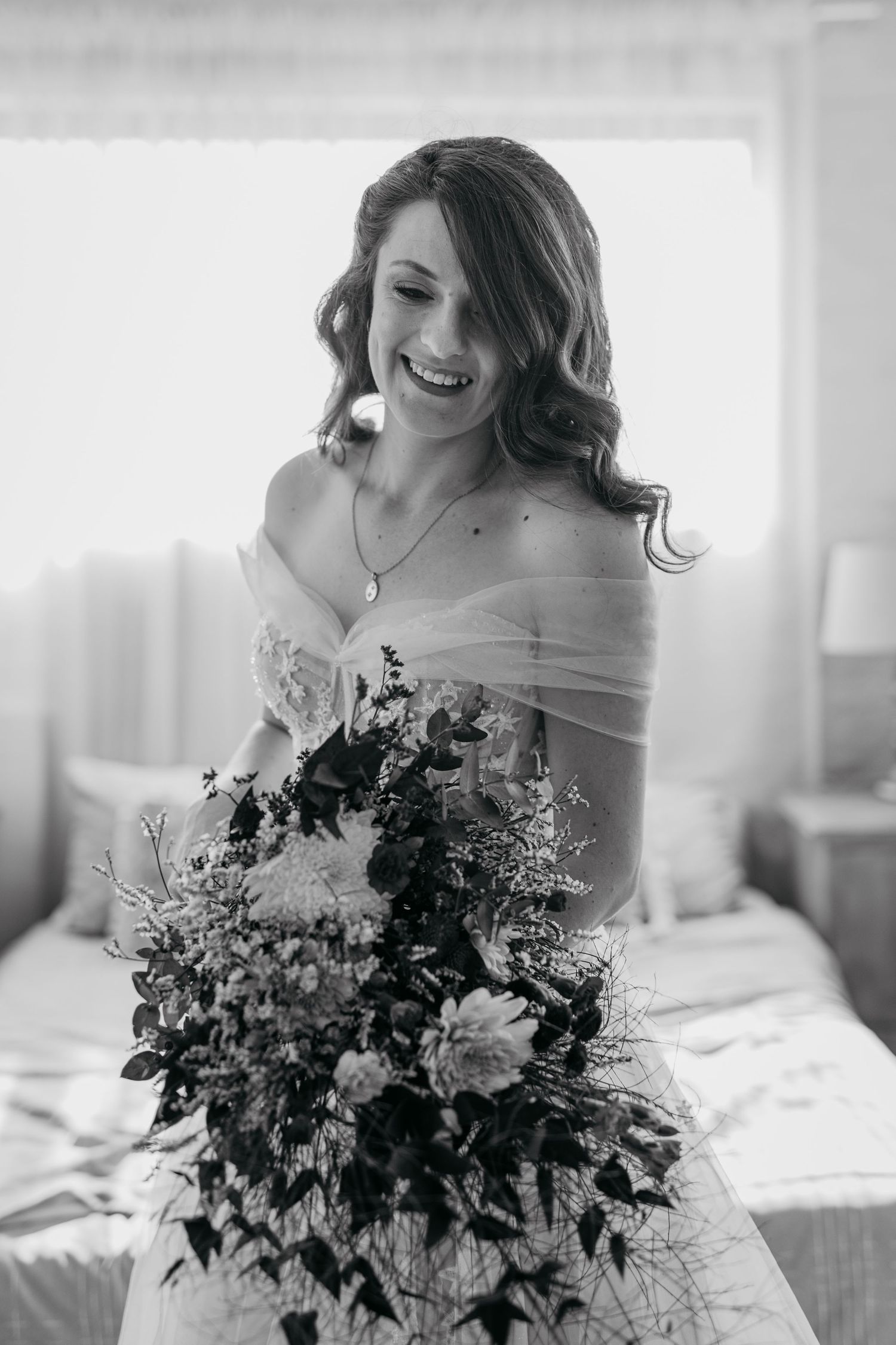Black and white portrait with romantic bouquet featuring cascading greenery and blooms.