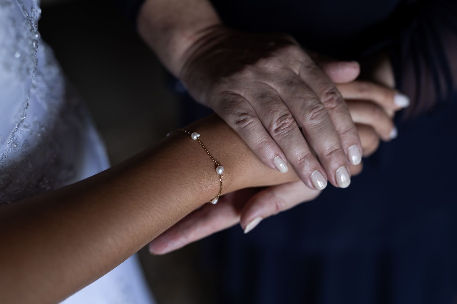 Close-up of hands touching in a tender moment during wedding preparations.
