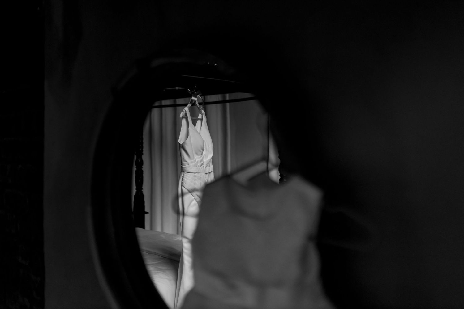 Artistic black and white reflection of wedding dress in mirror.