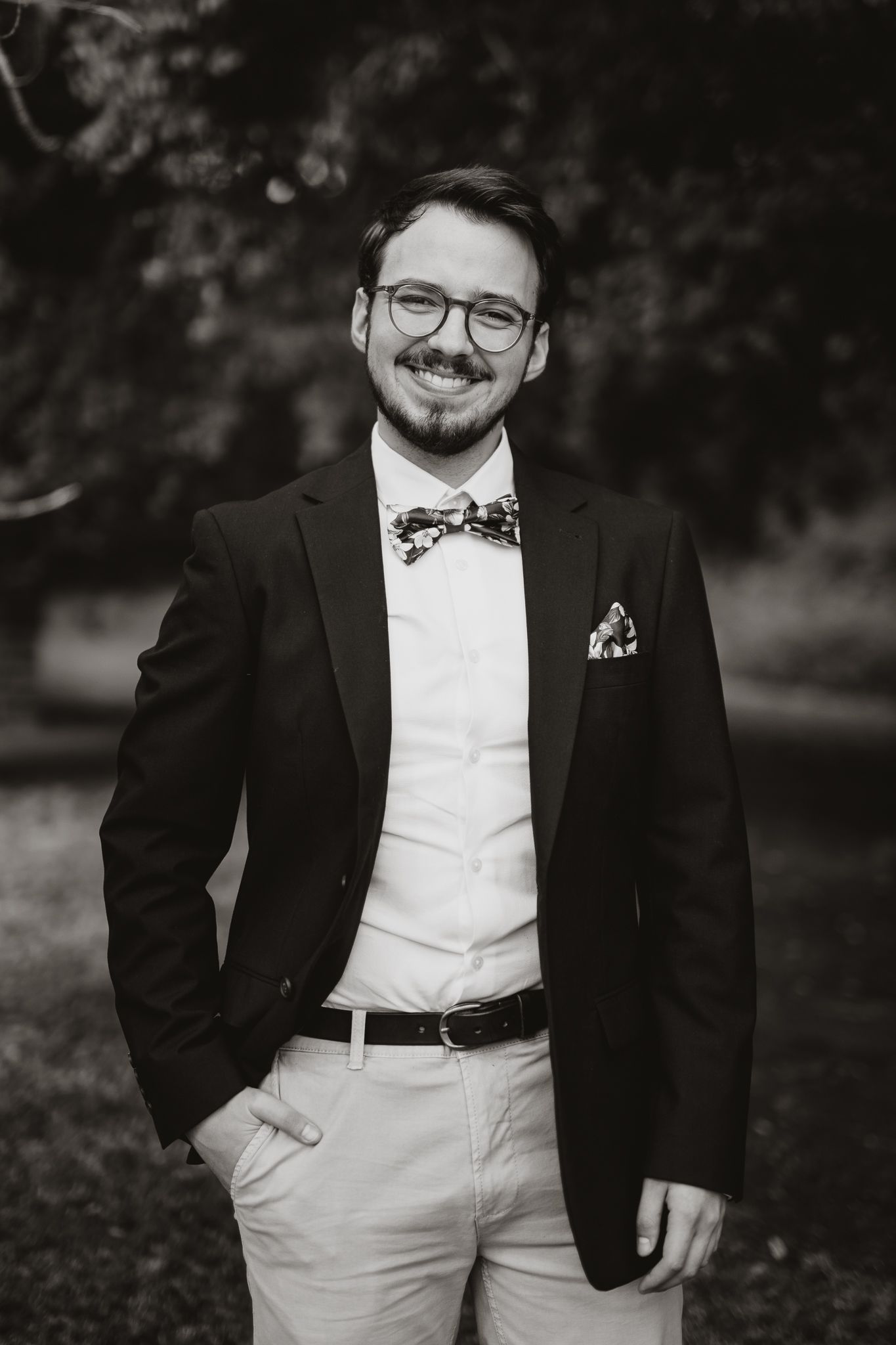Classic black and white portrait of groom in formal attire with bow tie.