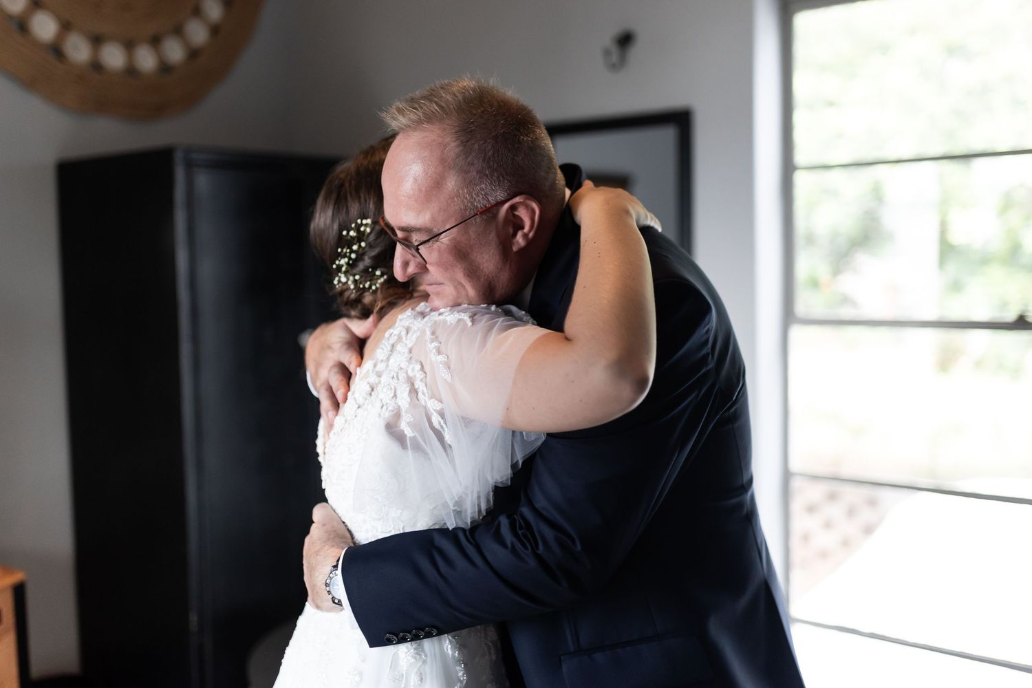 An intimate embrace shared during a heartfelt wedding day moment.