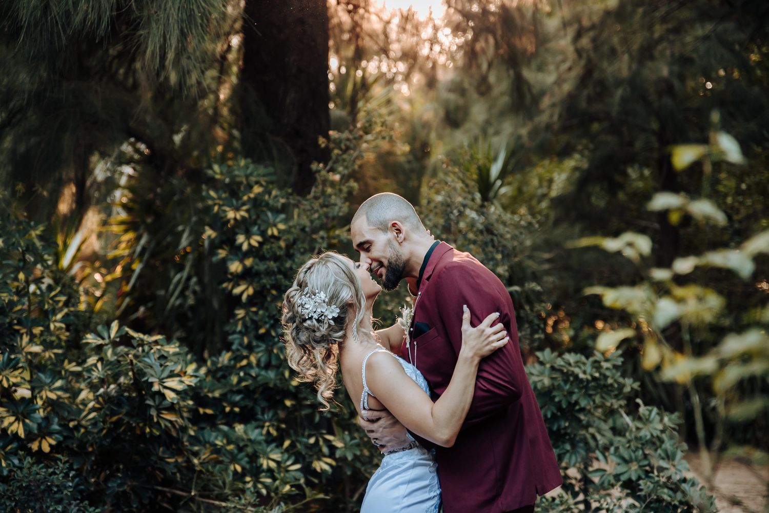 An intimate wedding moment captured between newlyweds in a lush garden setting.