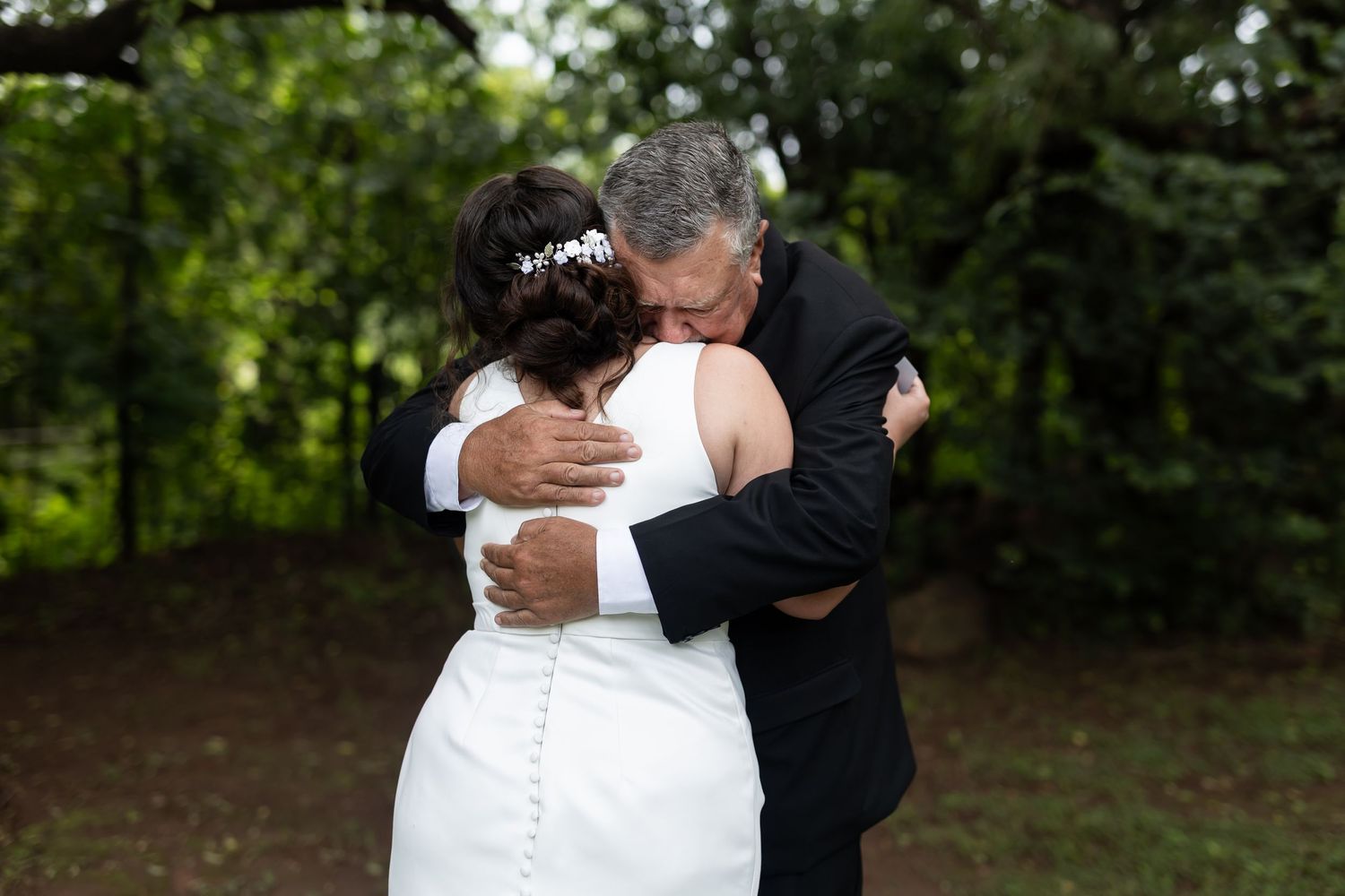 Emotional outdoor wedding moment captured between two people embracing during ceremony.