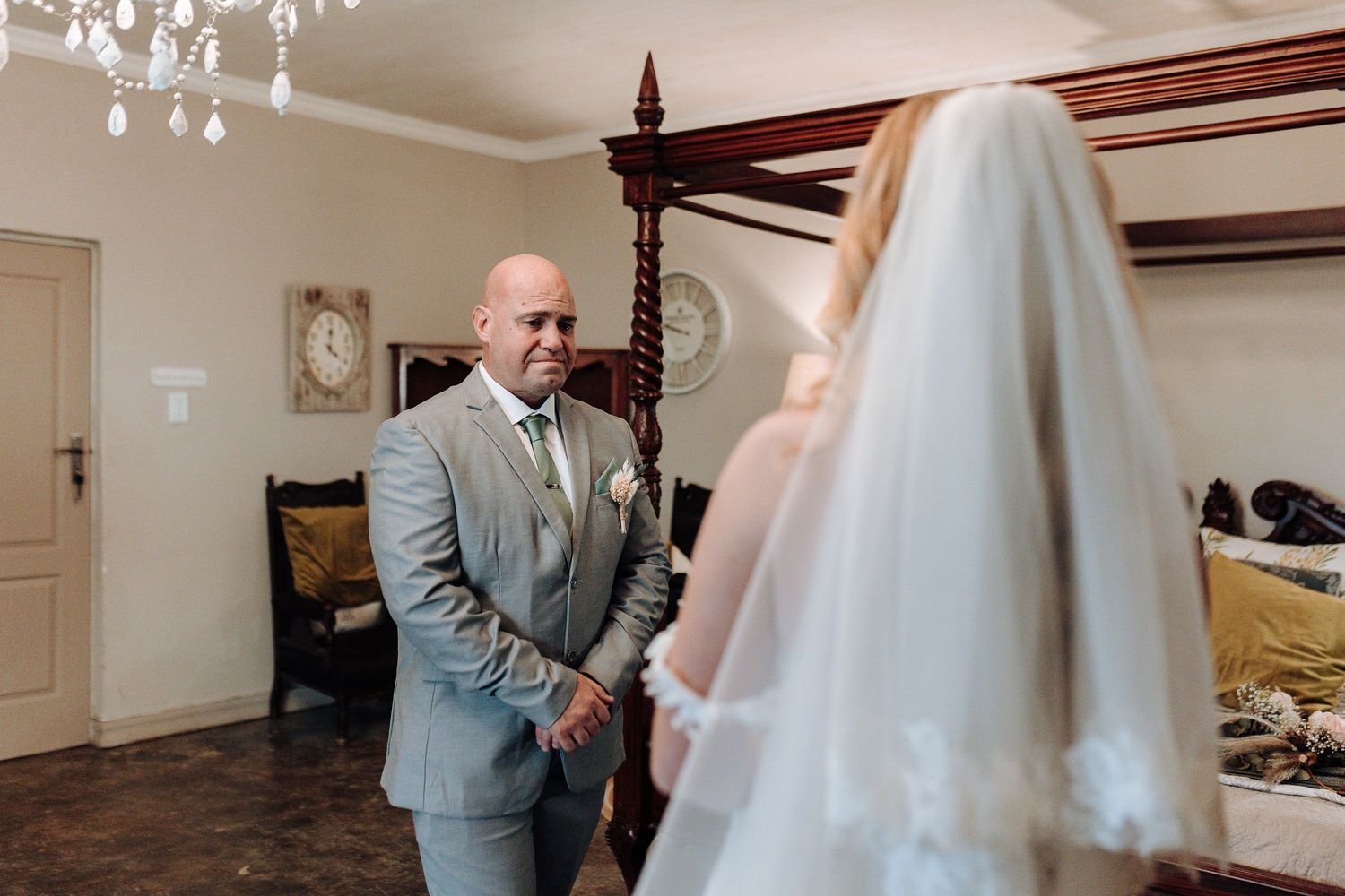 First look wedding moment captured in an elegant indoor setting with vintage furniture.