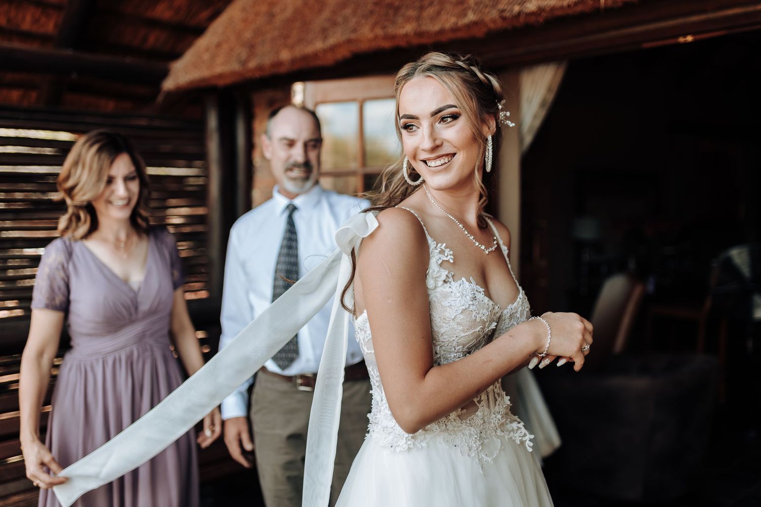 A joyful moment captured during wedding preparations in a rustic wooden setting.