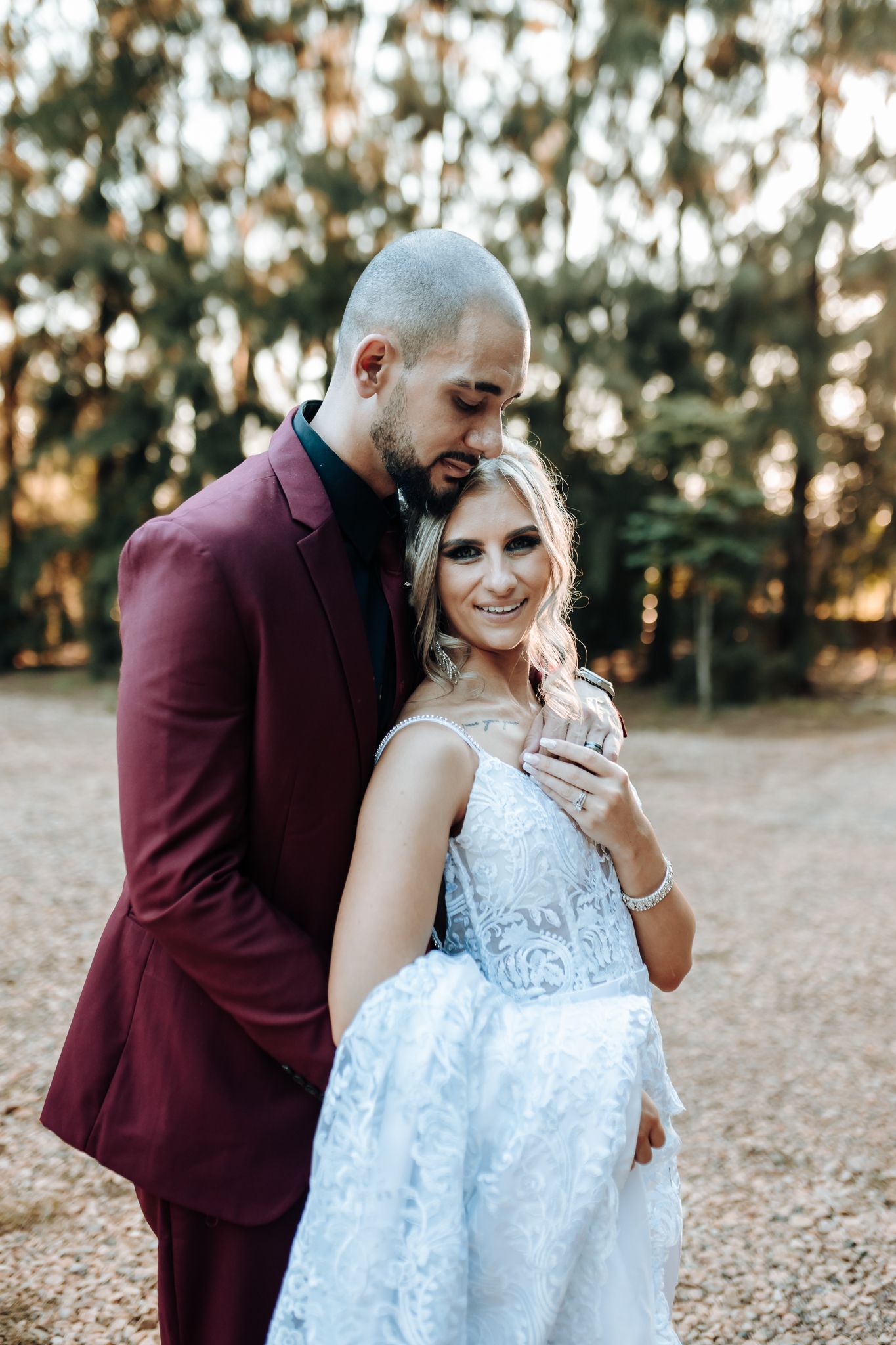 Outdoor wedding portrait showing light blue gown and burgundy suit.