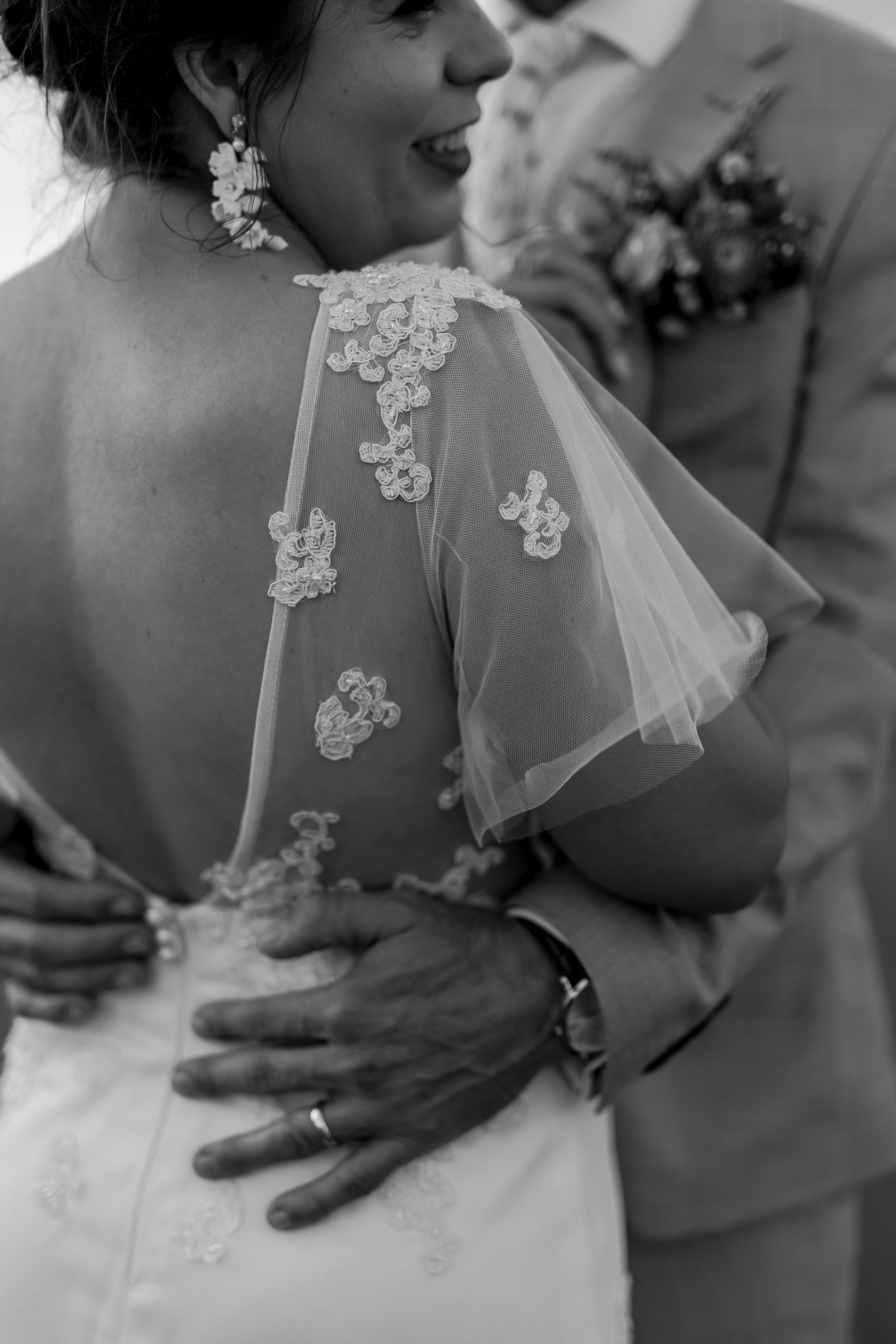 Close up of delicate lace detail on bride's wedding dress back.
