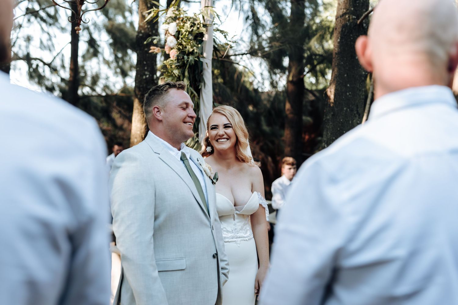 Light and airy forest wedding ceremony surrounded by towering pine trees.