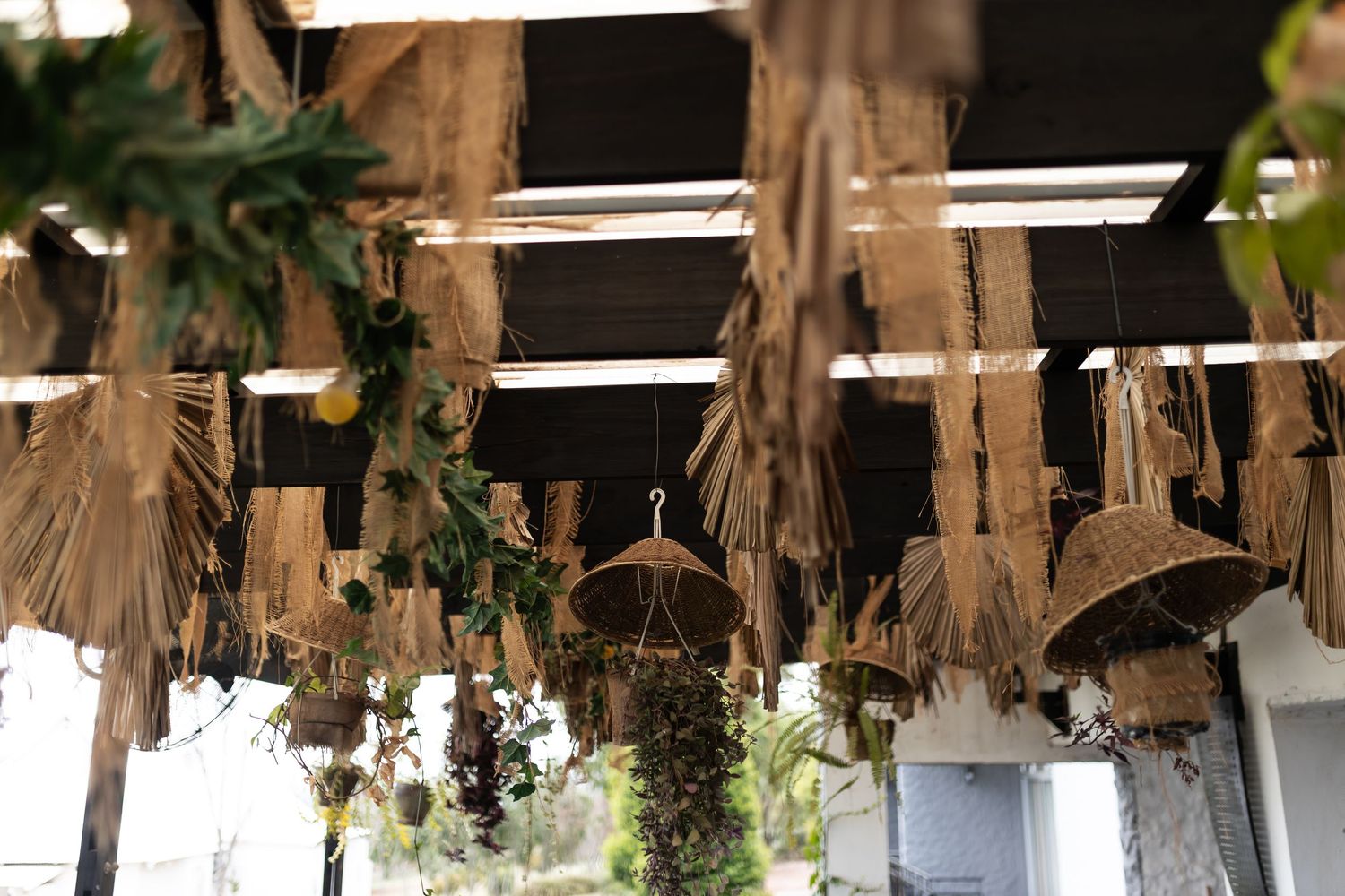 Rustic dried floral arrangements hanging from wooden beams create natural ceiling decor.